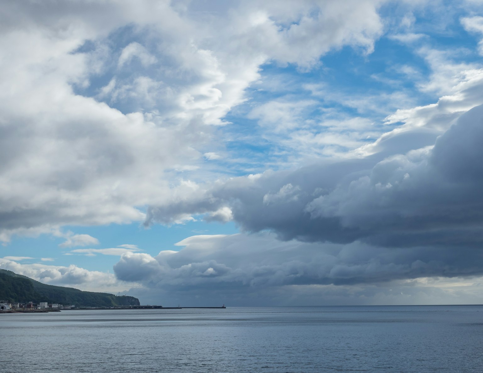 Vue de mer calme et ciel bleu avec des nuages flottants