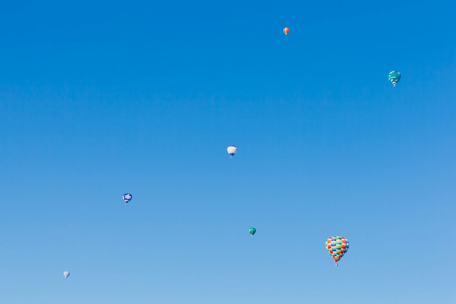 Bunte Heißluftballons, die in einem klaren blauen Himmel schweben