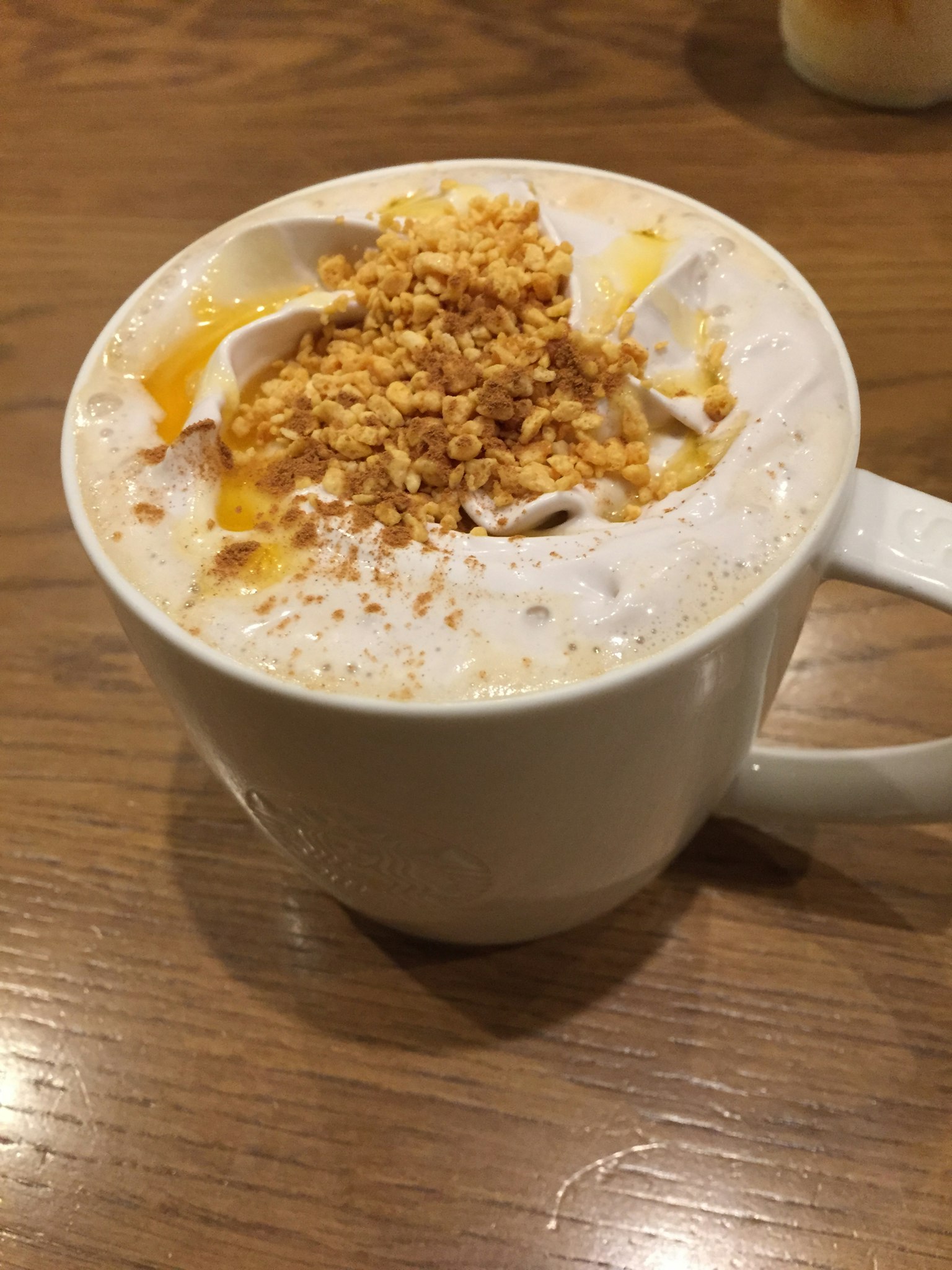 Bevanda calda cremosa guarnita con noci e salsa di caramello