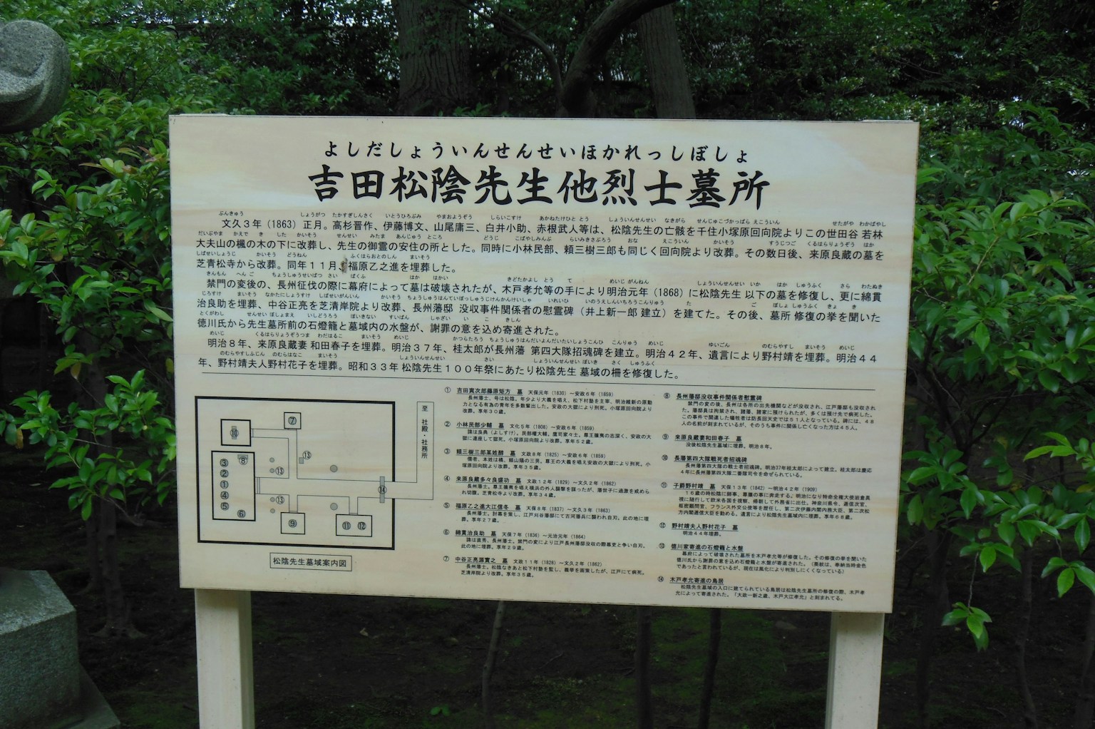 关于吉田松阴墓地的信息牌，周围环绕着绿色植被