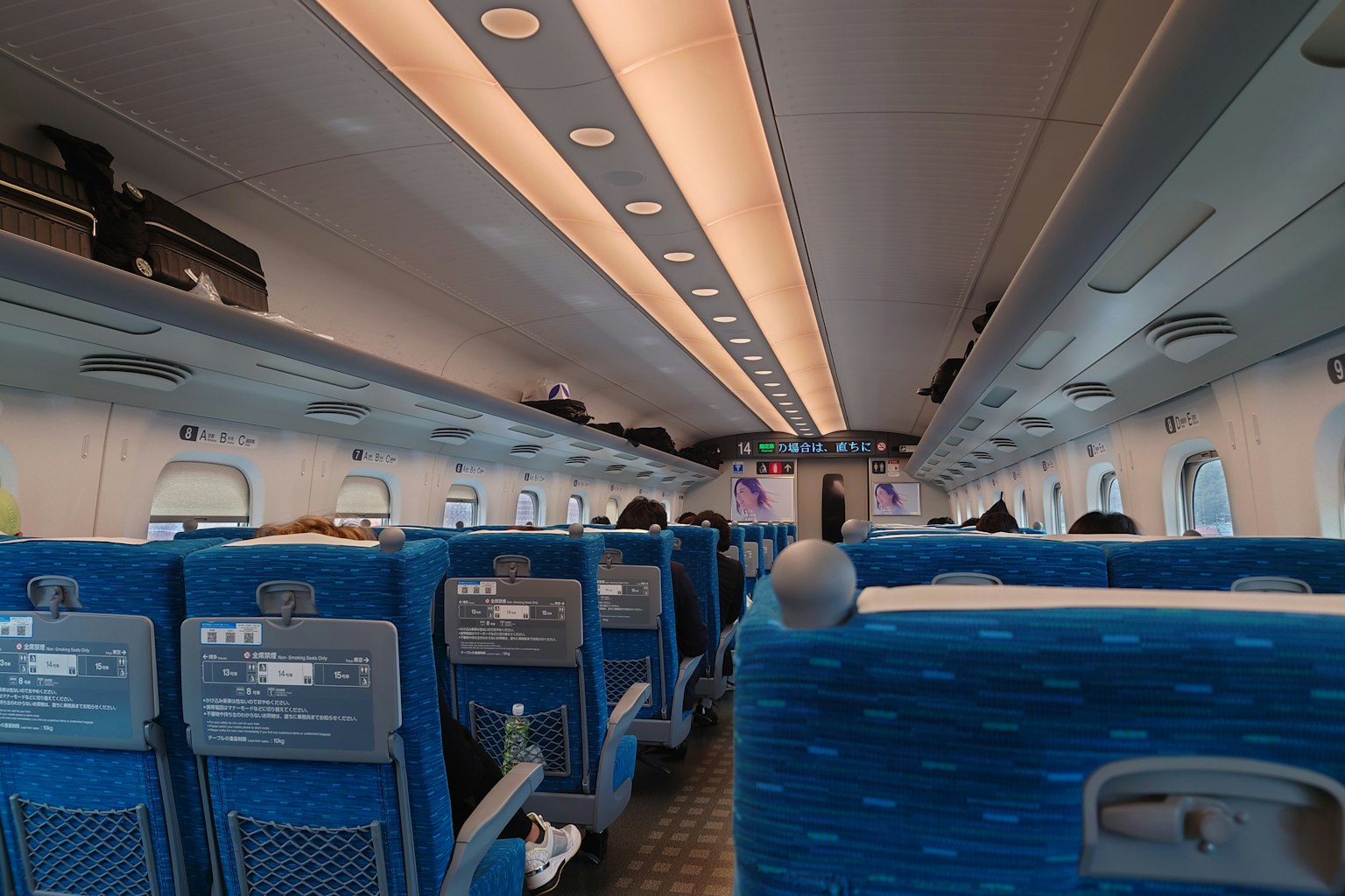Nội thất của tàu Shinkansen với ghế màu xanh và ánh sáng sáng