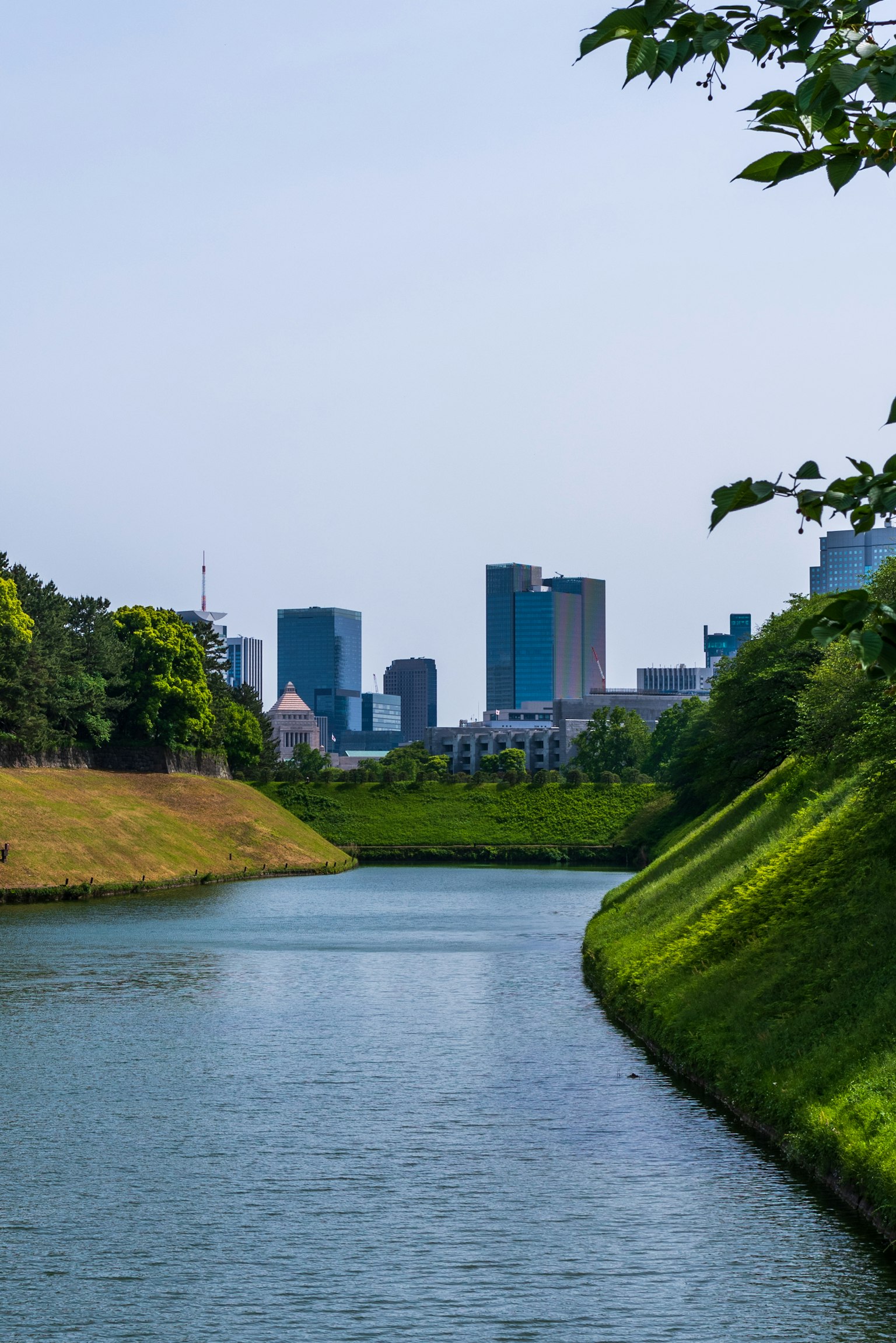城市风光，河流和绿色山丘在蓝天之下
