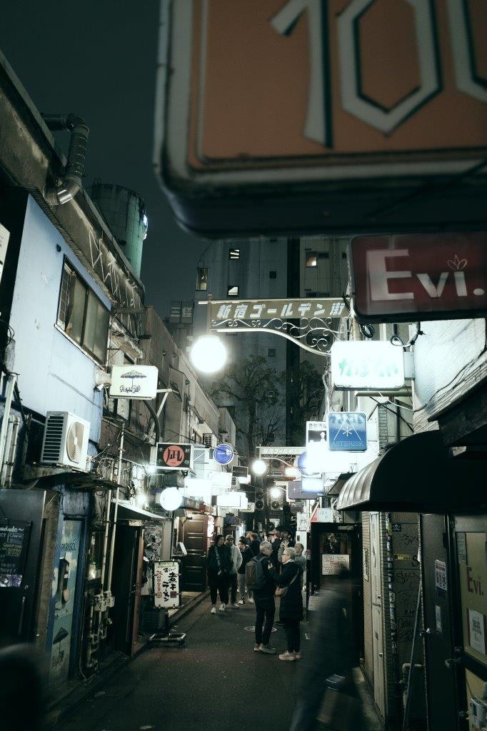 狭い路地の商店街と看板が並ぶ夜の街並み