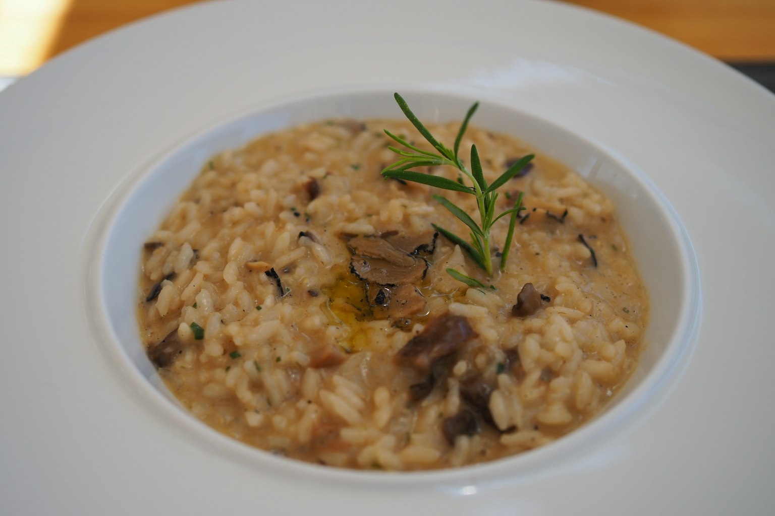 Risotto cremoso guarnito con erbe in una elegante ciotola bianca
