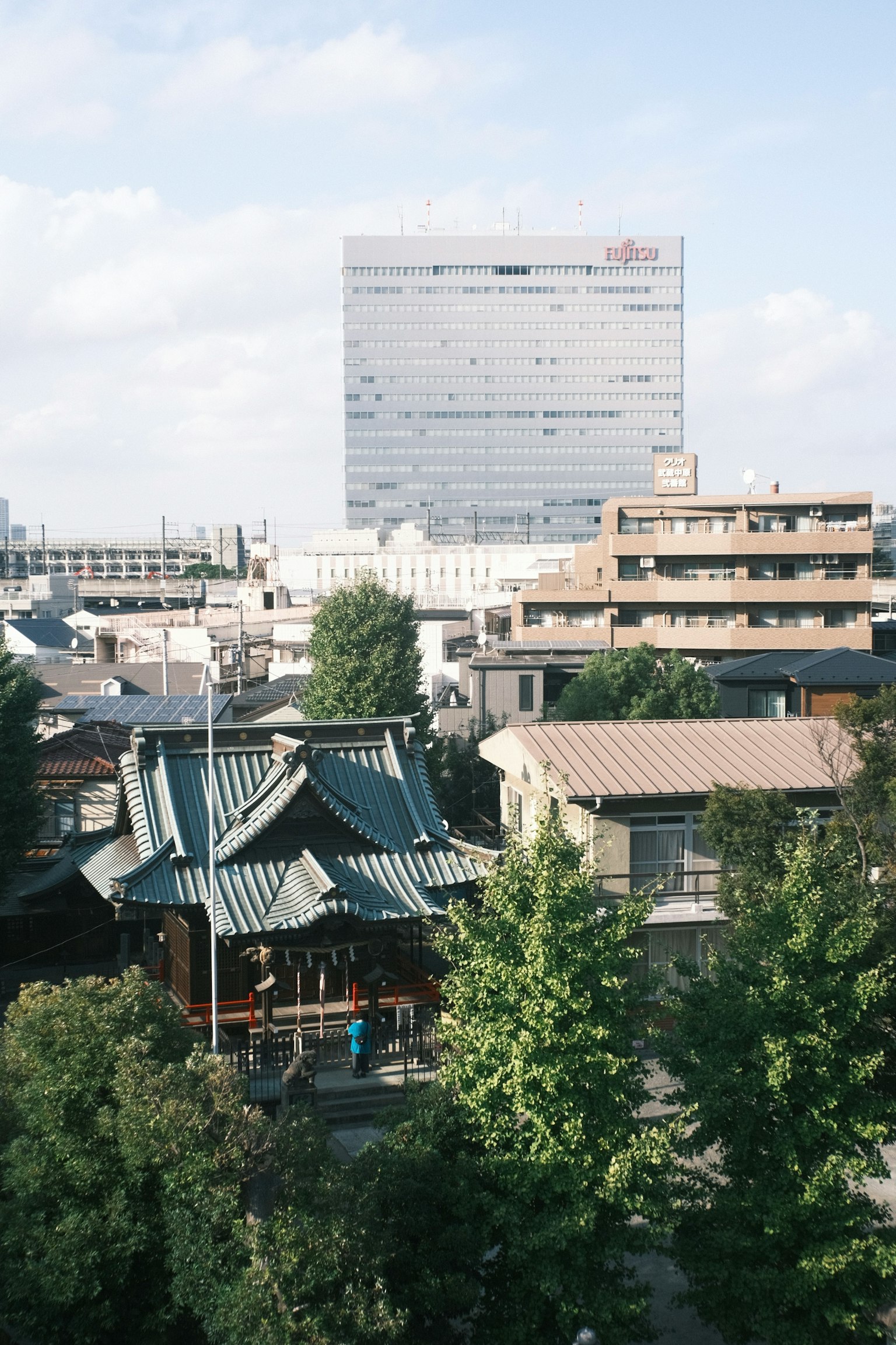 Urban landscape featuring a high-rise building and a traditional shrine