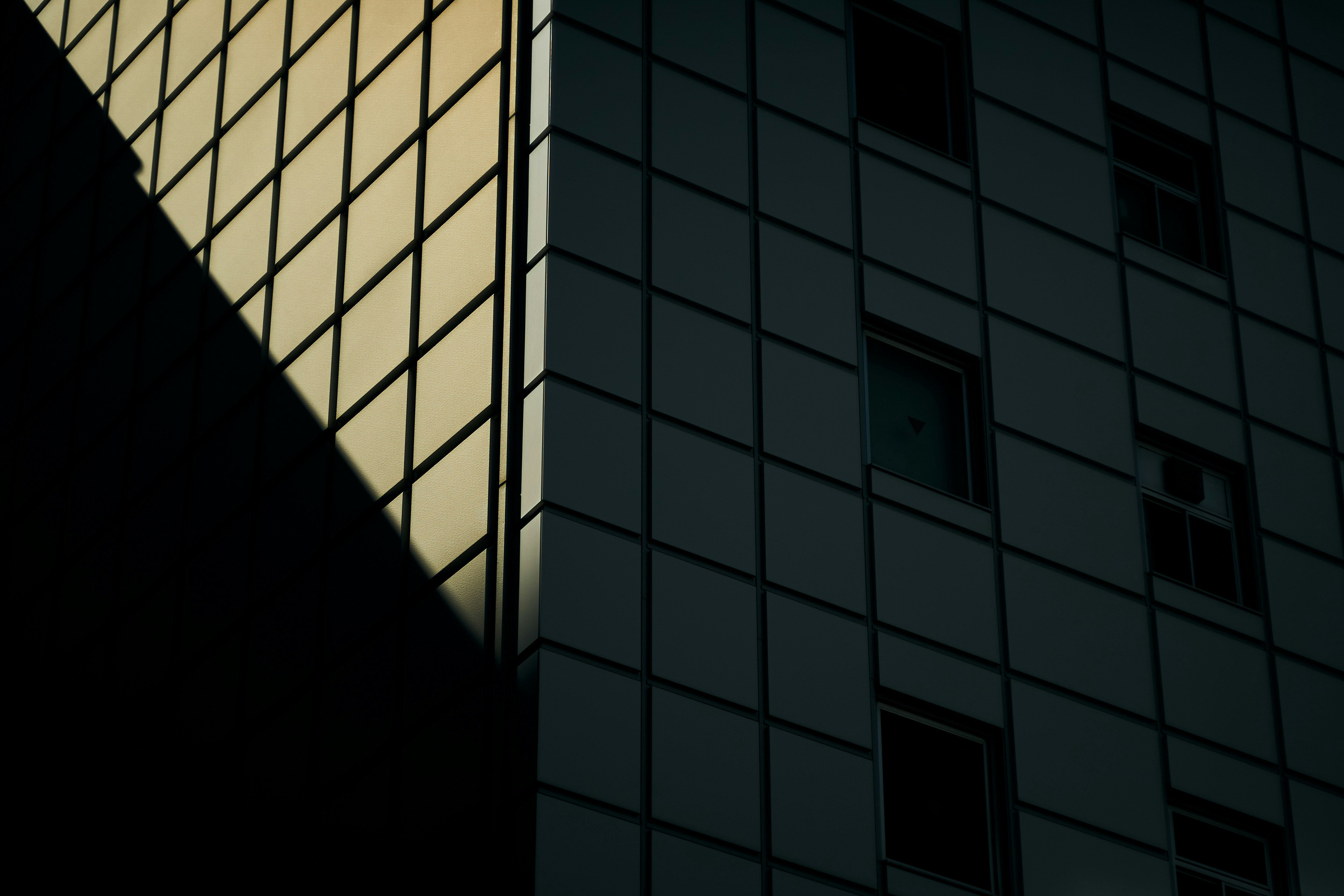 Lumière diagonale et ombres sur la façade d’un immeuble