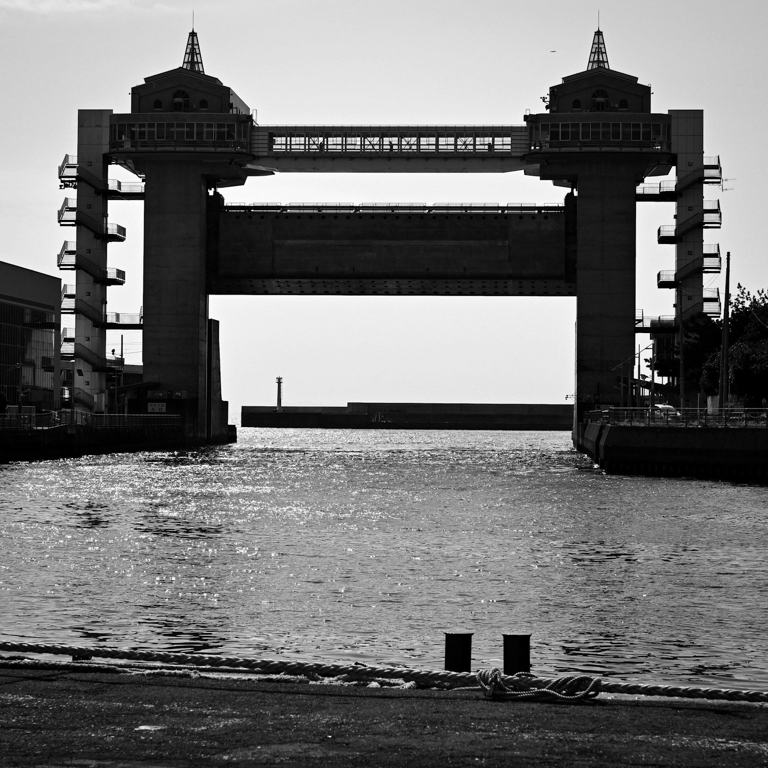 Black and white image of a sluice gate structure spanning a river