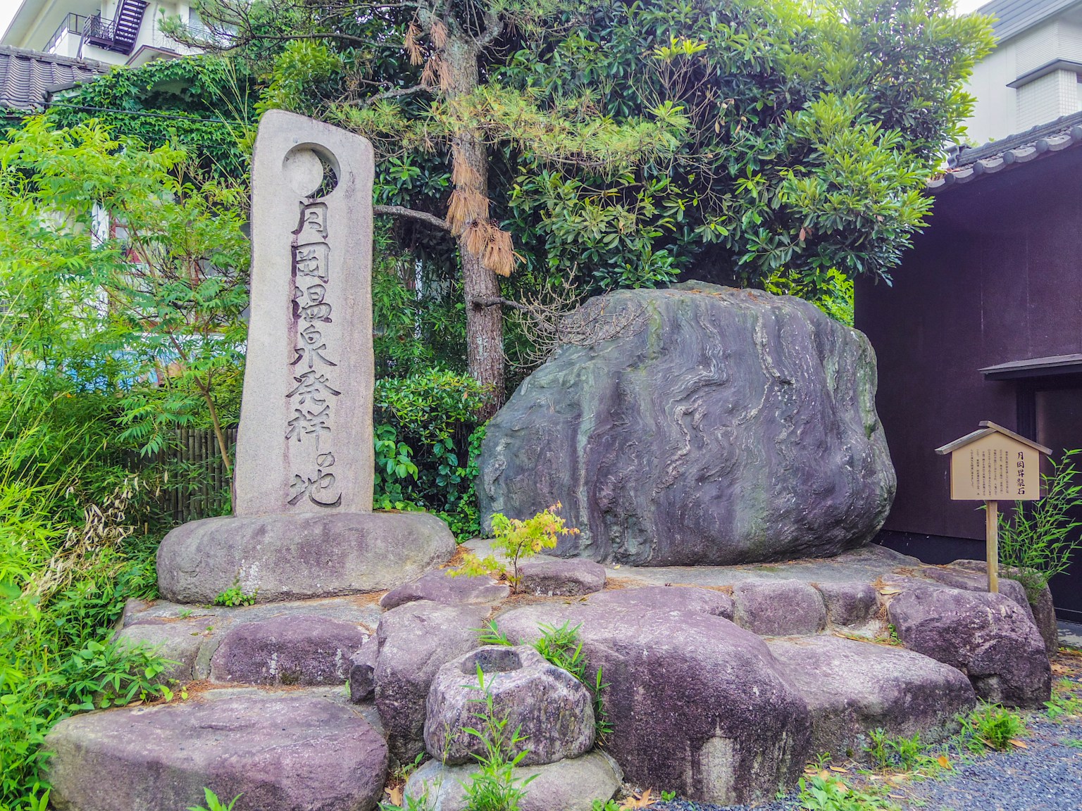 一个大石头和纪念碑在郁郁葱葱的环境中