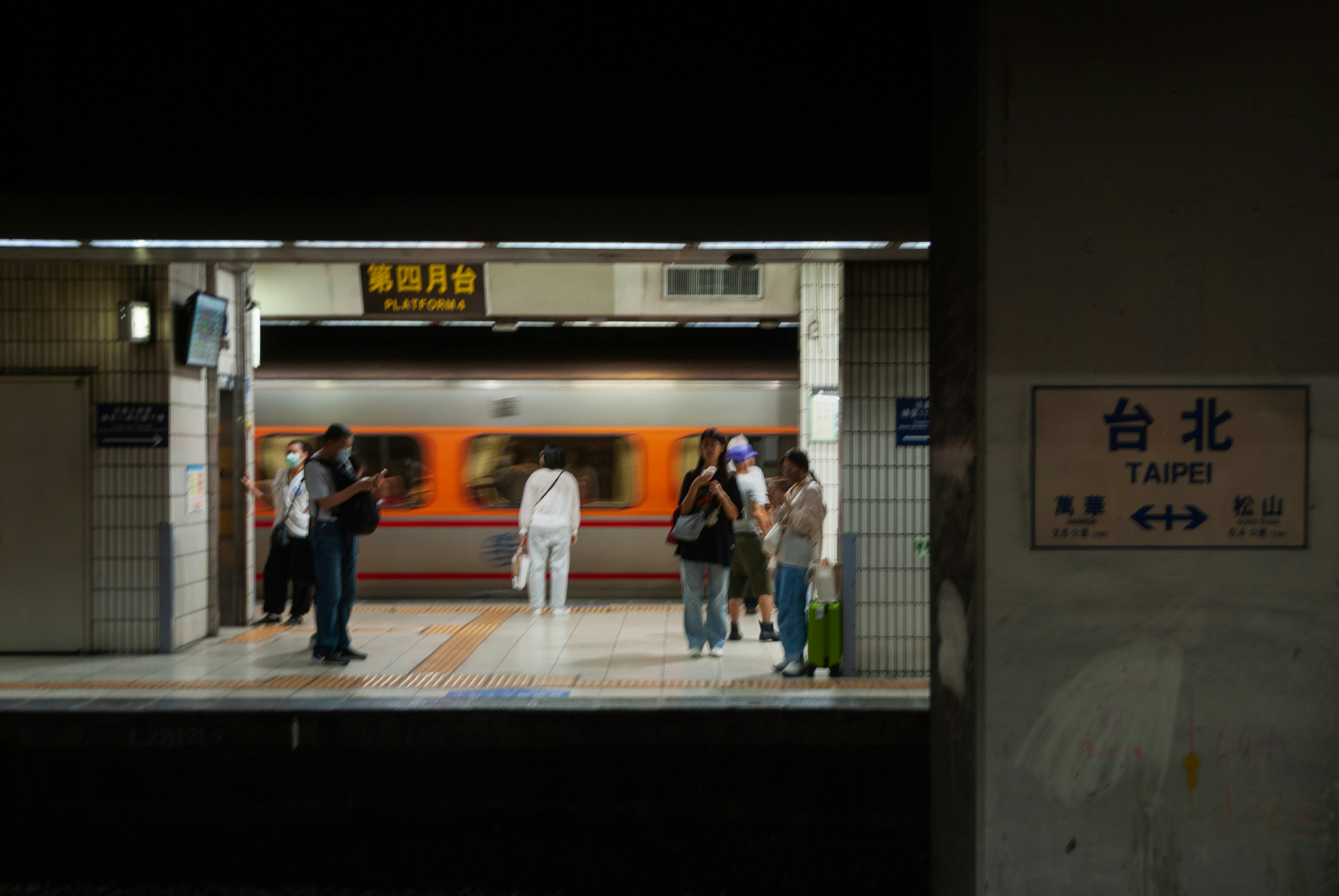 台北の駅ホームで電車を待つ人々