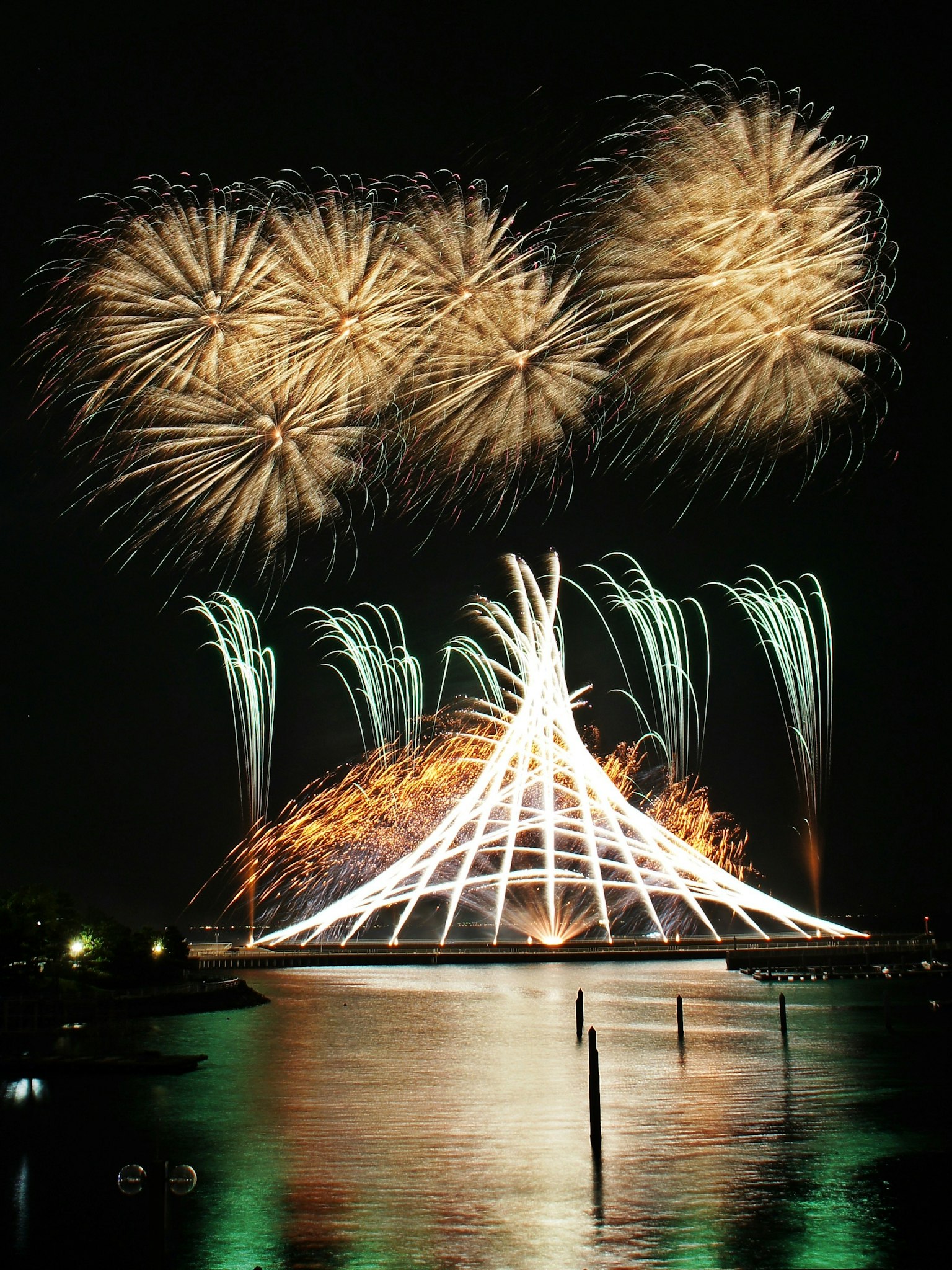 Stupenda esposizione di fuochi d'artificio sull'acqua con riflessi notturni