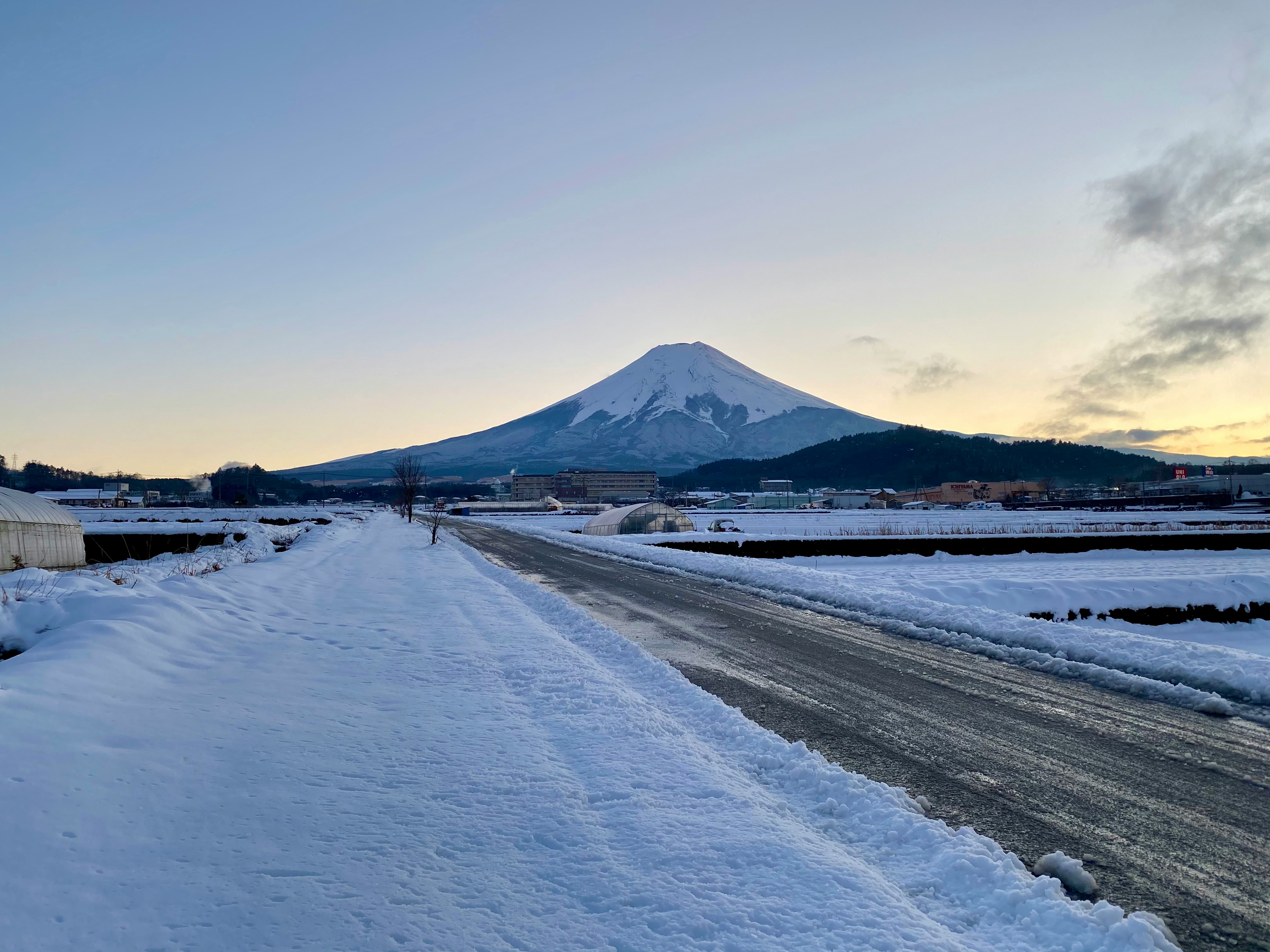 strada innevata con una montagna lontana al crepuscolo