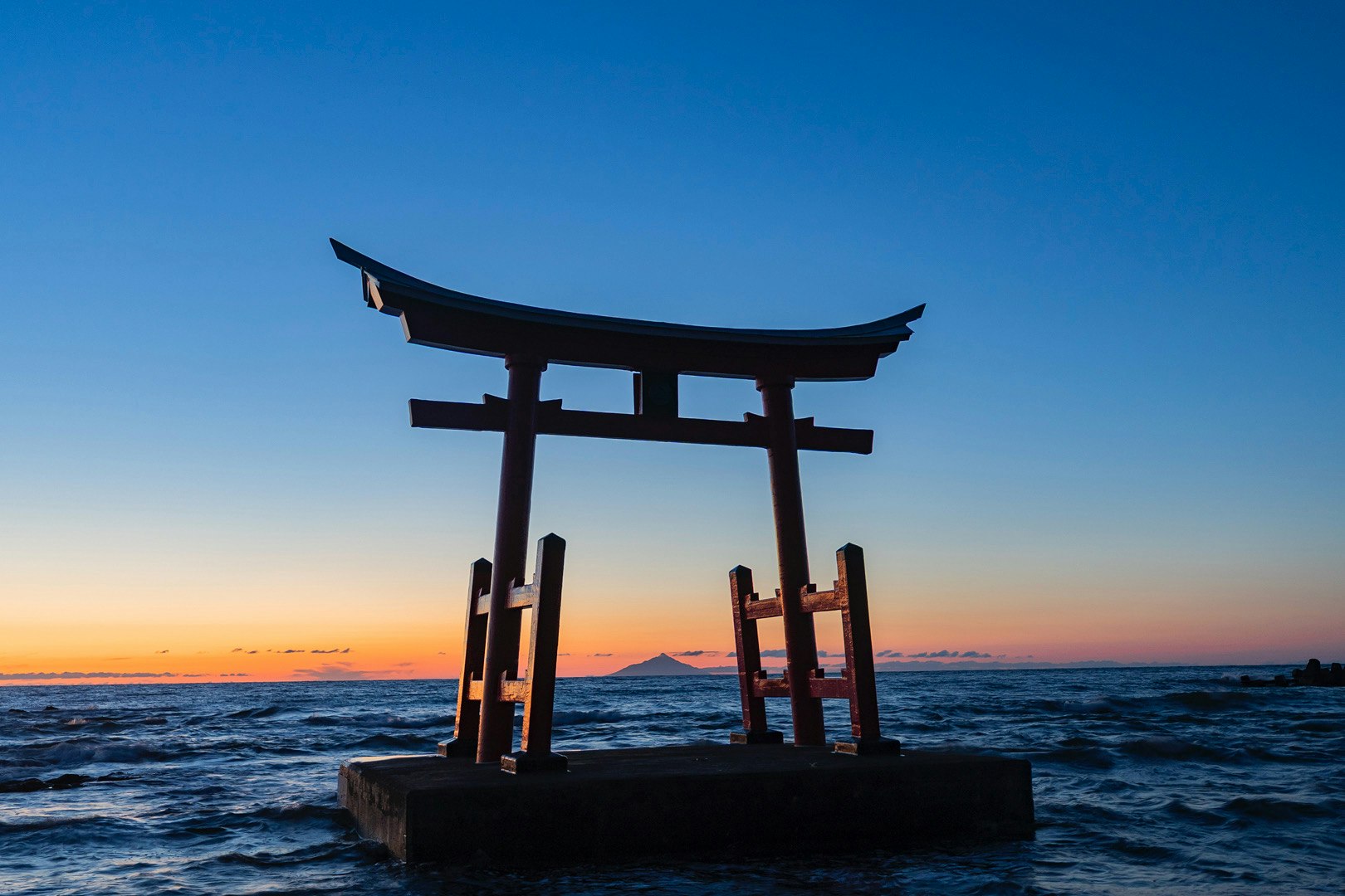 夕暮れの海に立つ鳥居