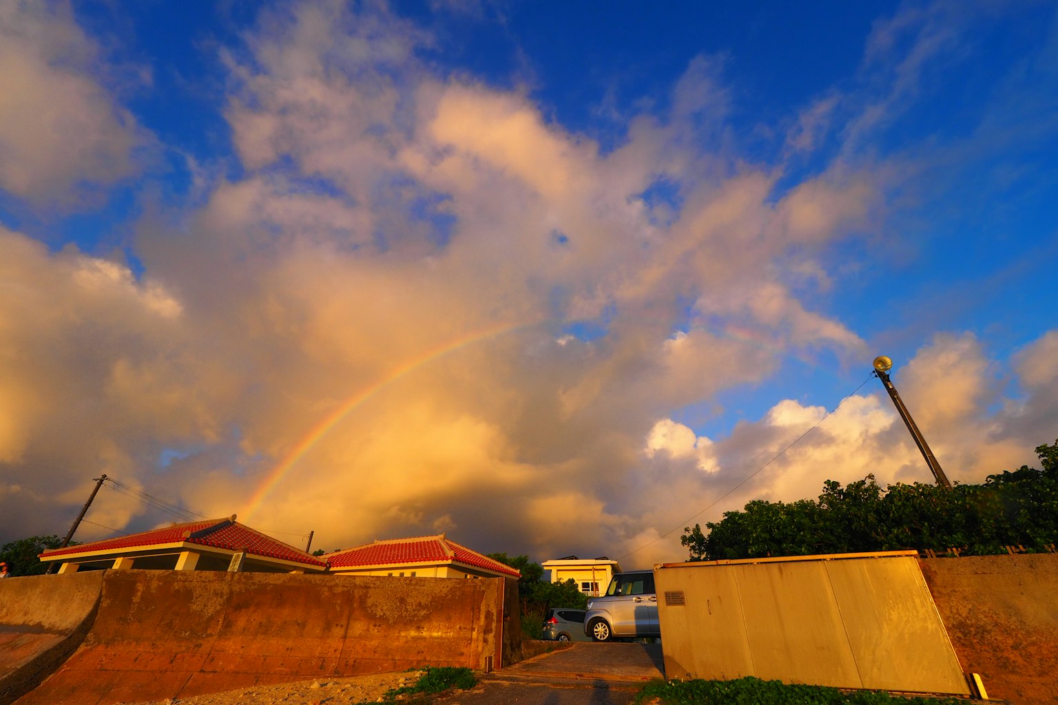 一道彩虹橫跨藍天,雲朵和房屋