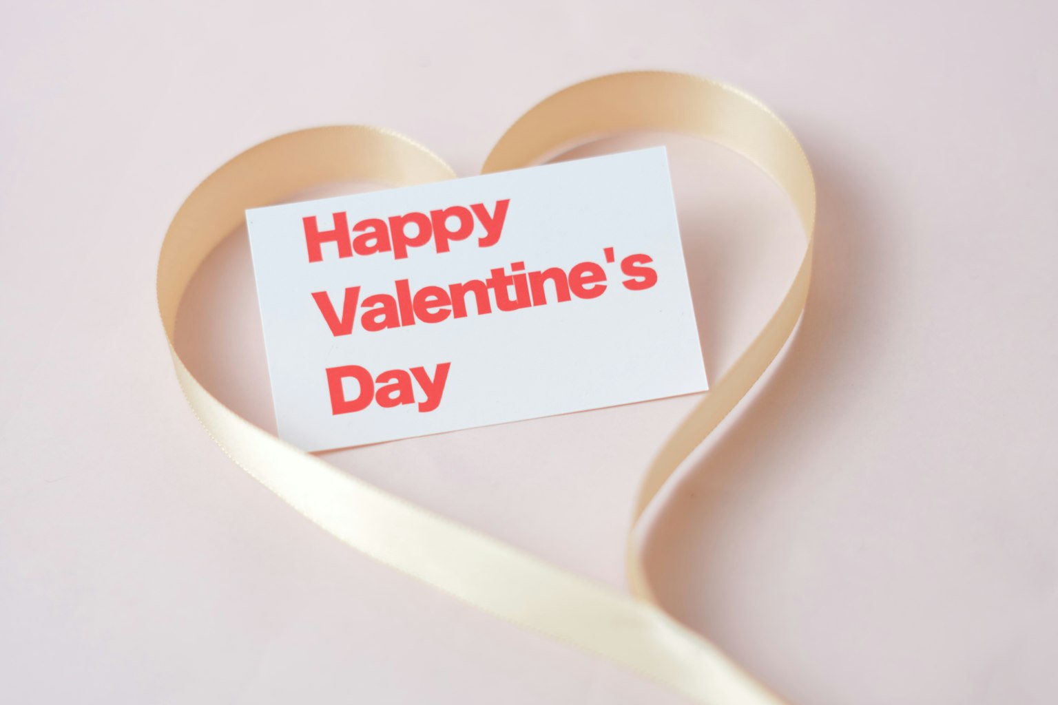 Una carta di San Valentino posata su un nastro a forma di cuore