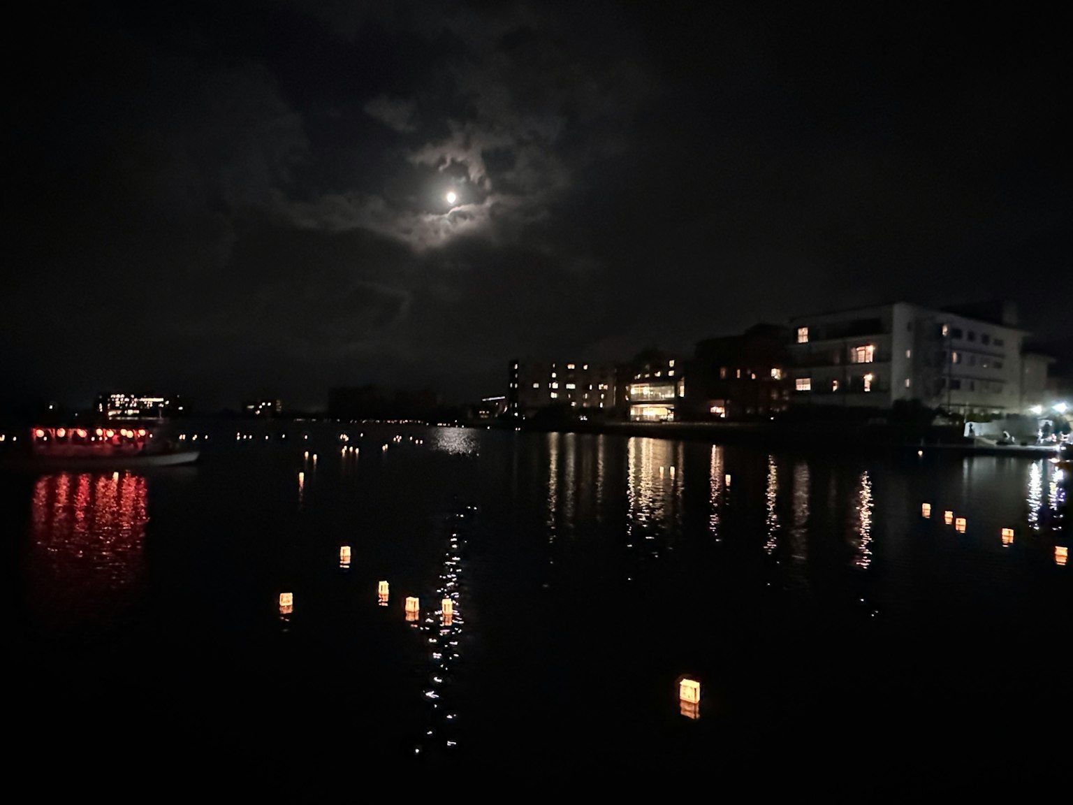 Bella scena notturna con lanterne galleggianti sul lago e riflessi della luna