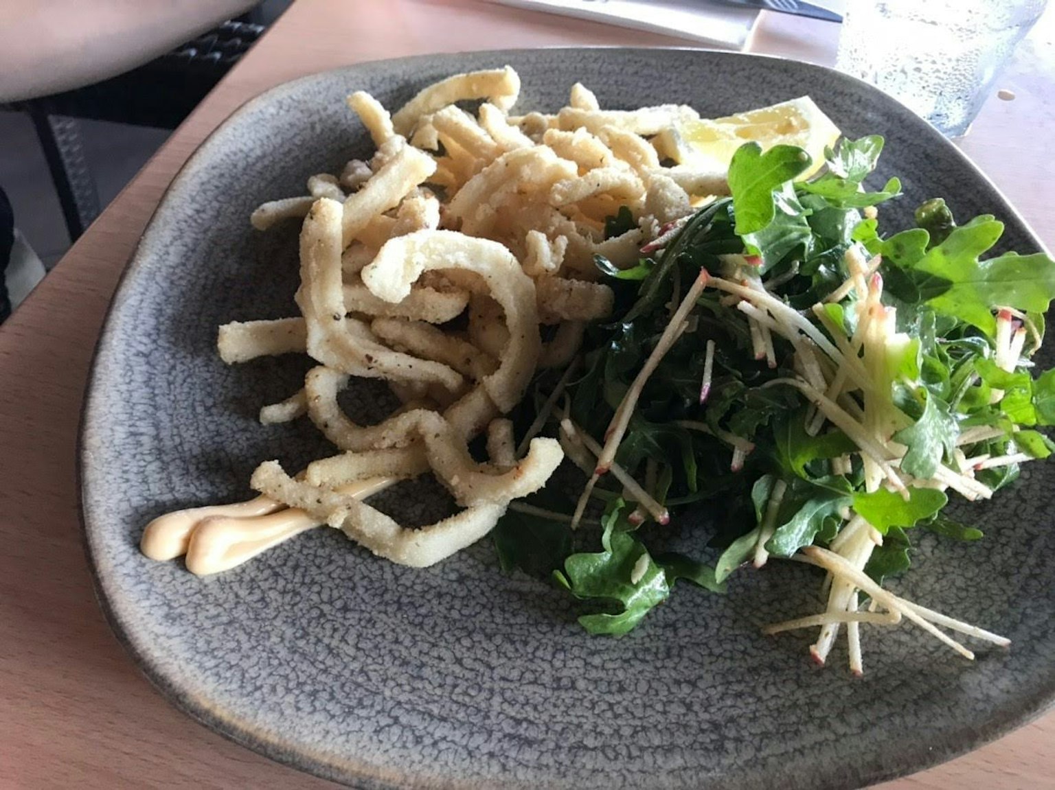 盤子裡有脆炸麵條和新鮮香草