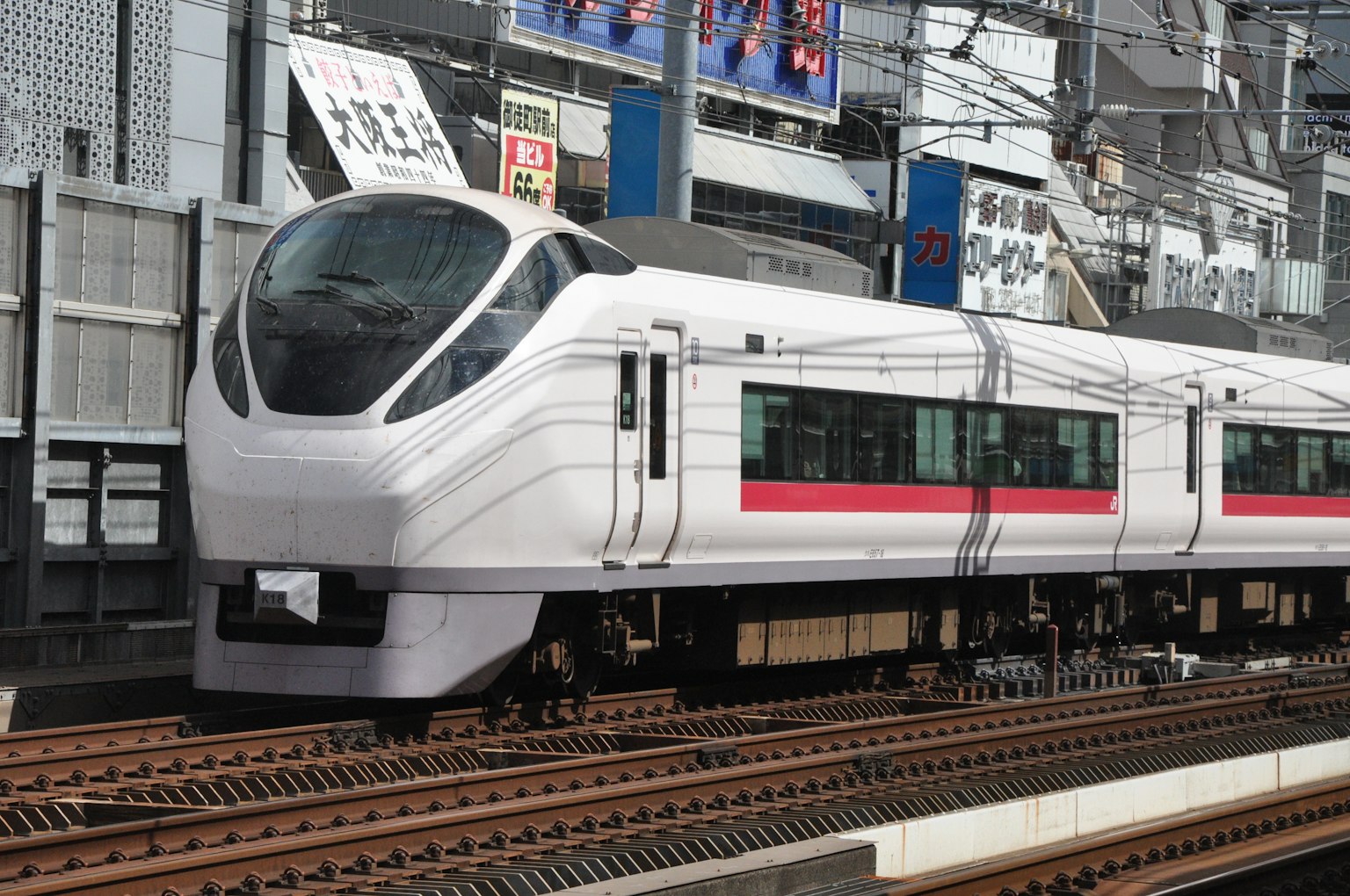 Tàu Shinkansen màu trắng có sọc đỏ đậu tại ga