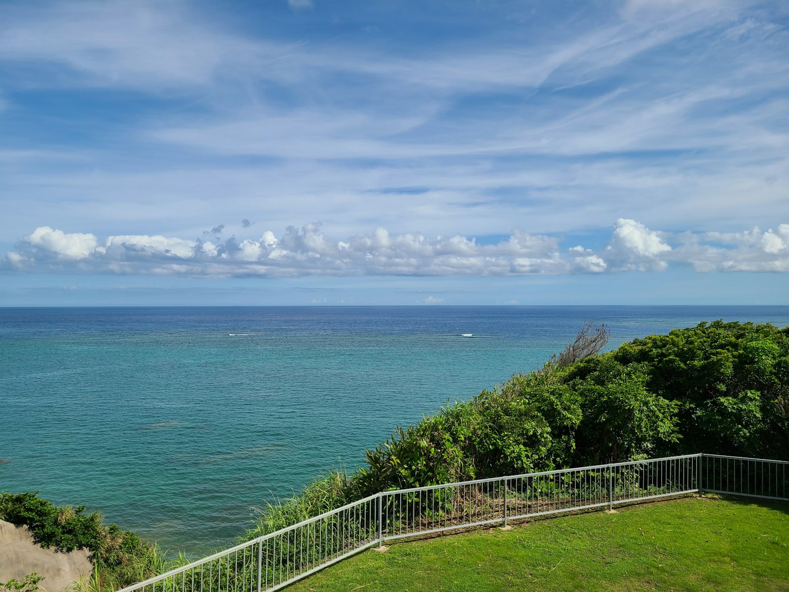 Malersicher Blick auf den blauen Ozean und weiße Wolken unter klarem Himmel