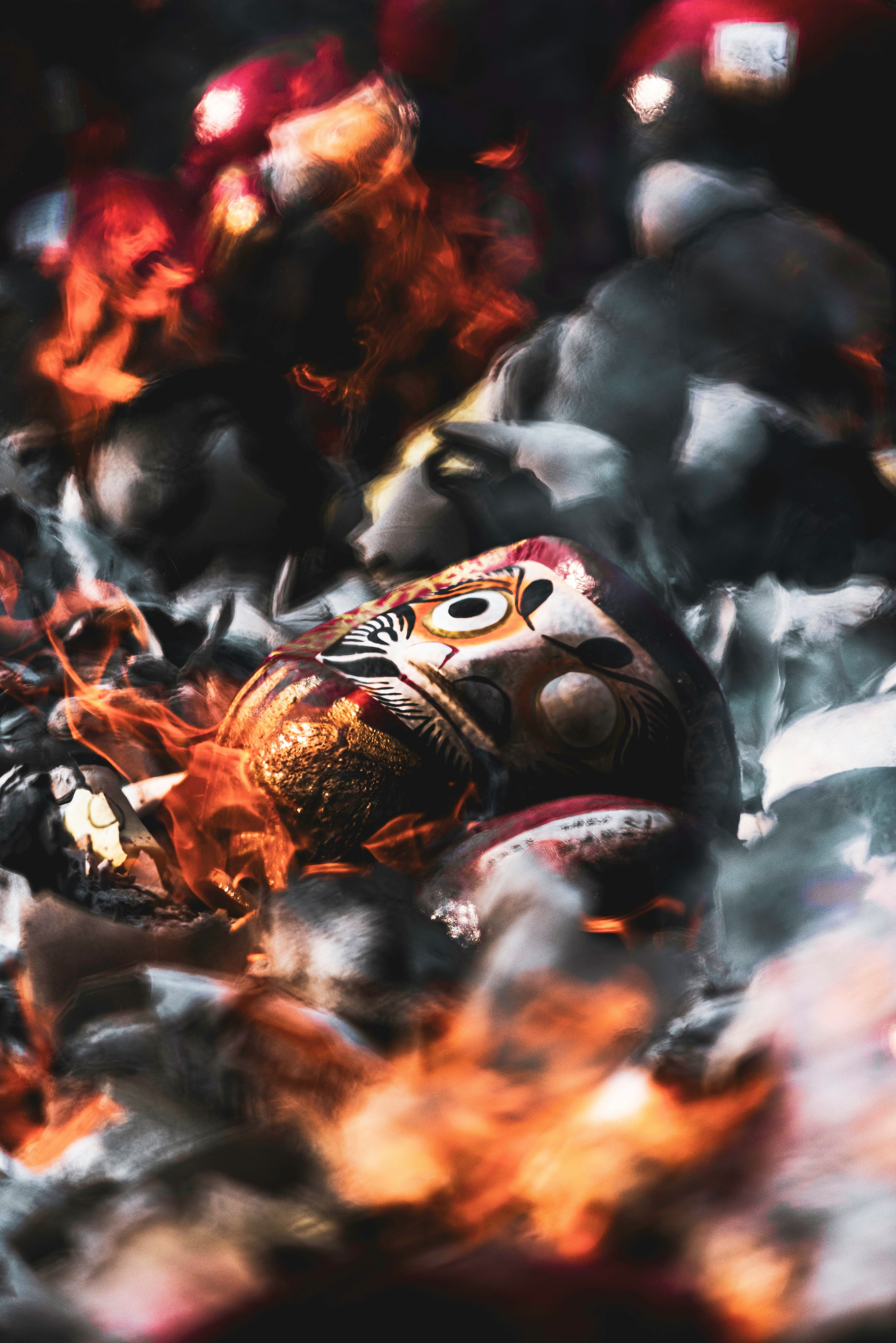 Colorful fabric or doll-like objects burning amid flames and smoke