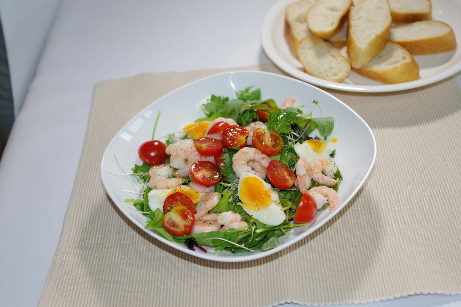 Una ciotola di insalata con gamberi, pomodorini e uova a fette