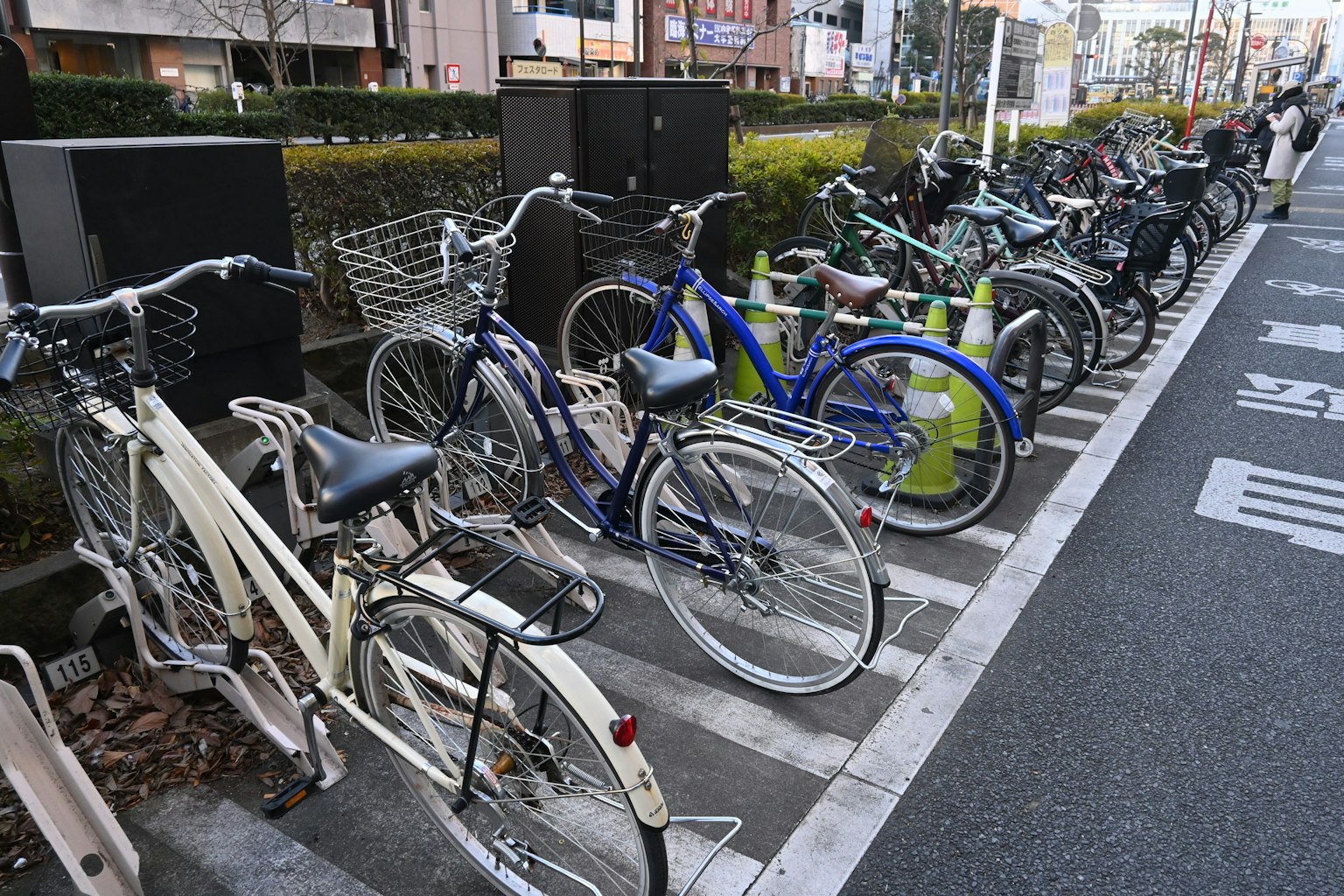 A row of various bicycles parked in a bicycle rack