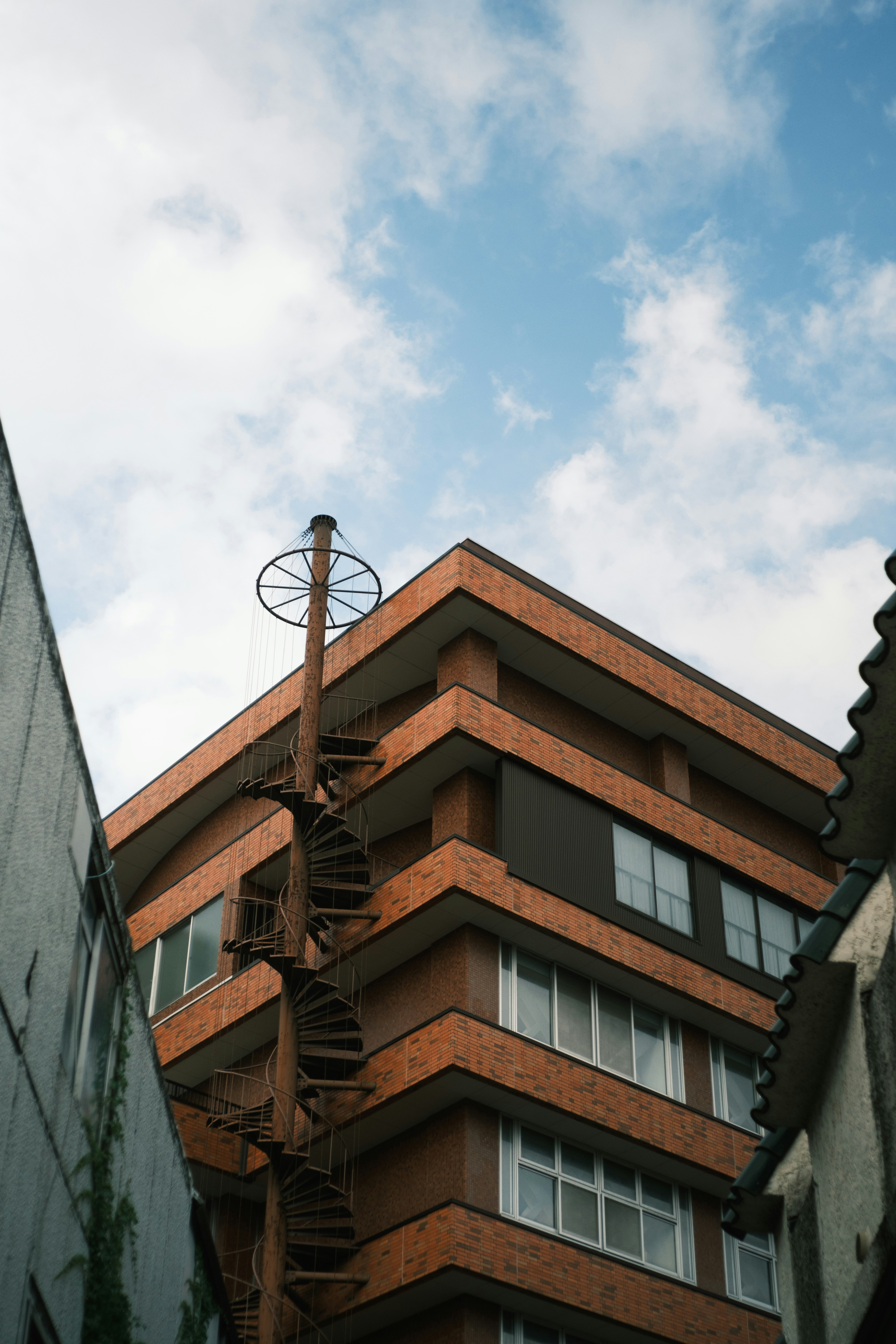 空と煉瓦の建物が見える狭い路地の上空
