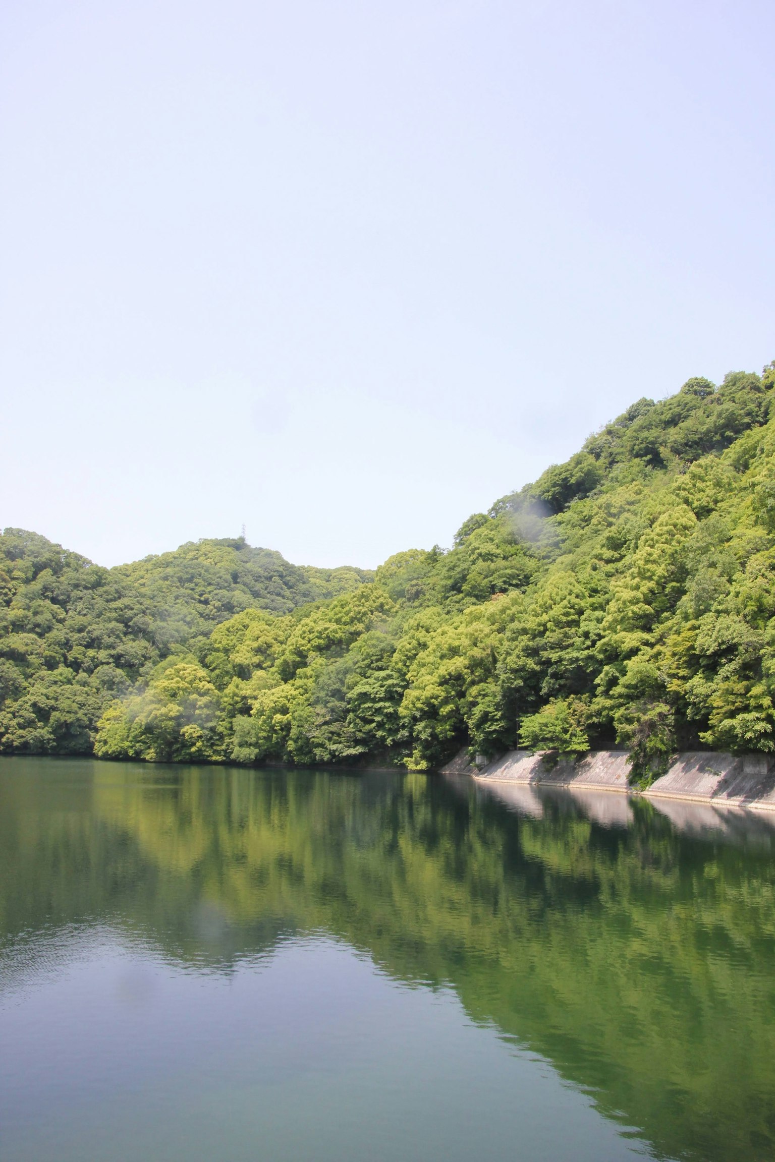 Montañas verdes reflejándose en un lago sereno
