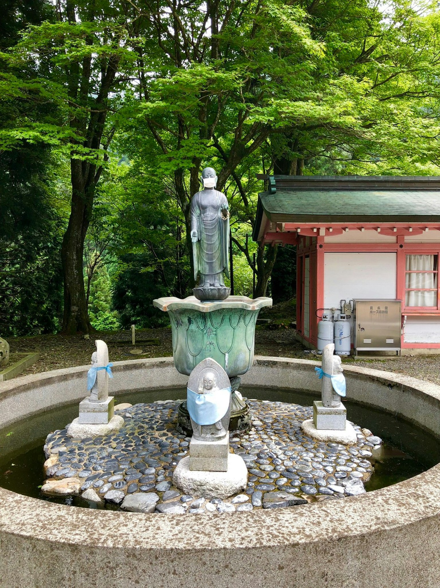 Una fuente serena con una estatua en el centro rodeada de vegetación exuberante