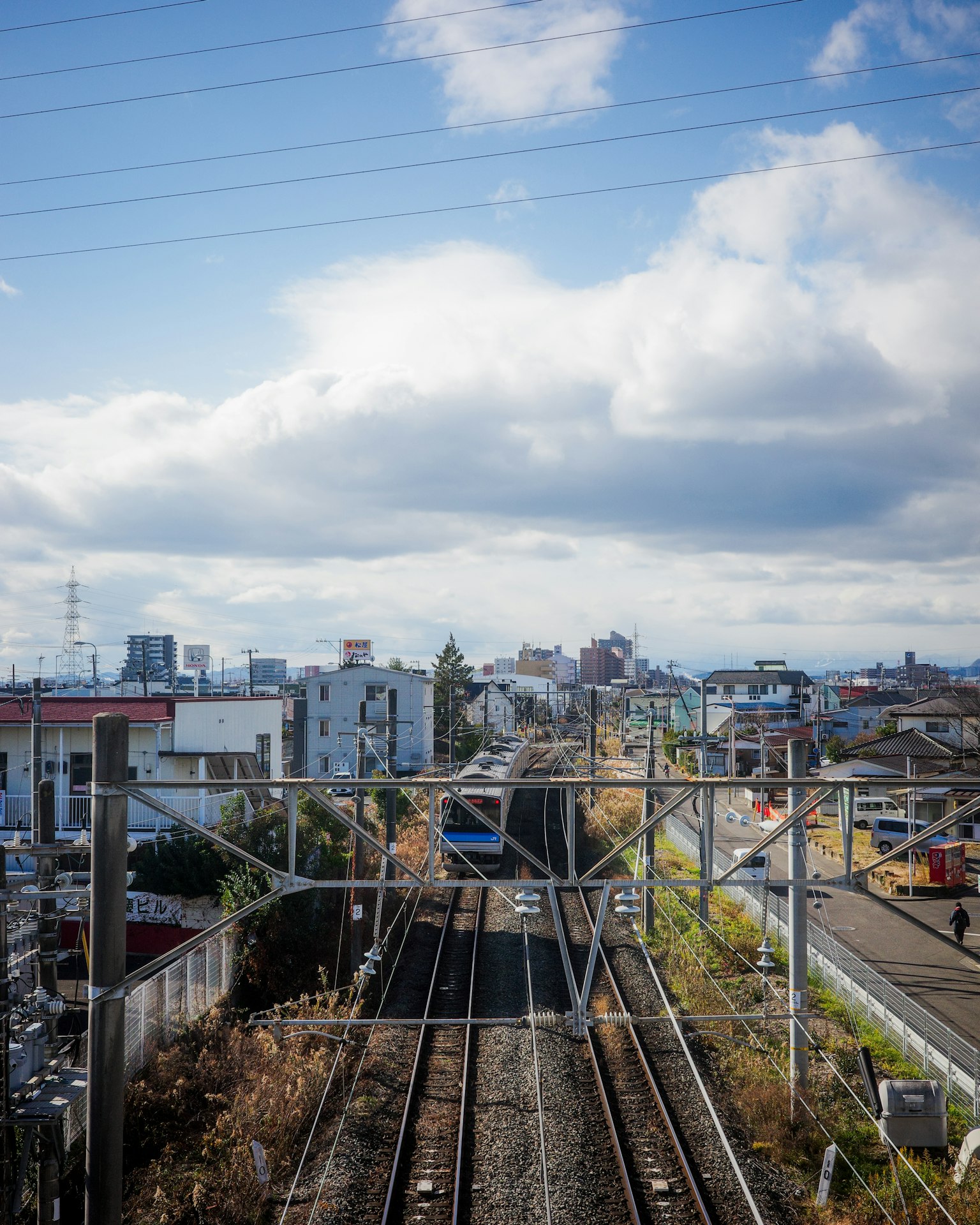 ทิวทัศน์ของรางรถไฟและภูมิทัศน์เมืองใต้ท้องฟ้าสีฟ้า