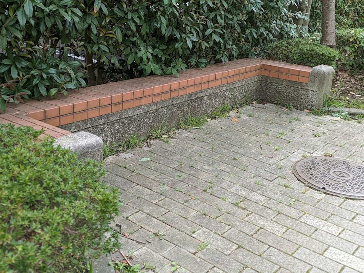 Corner brick bench with stone pavement in a park