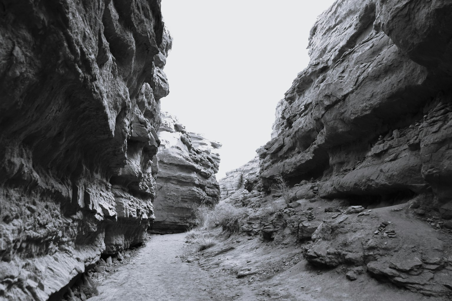 Sentiero stretto attraverso un canyon scuro con alte pareti rocciose