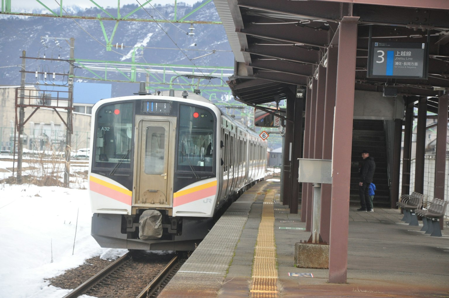Train stopped at a snowy station with a platform