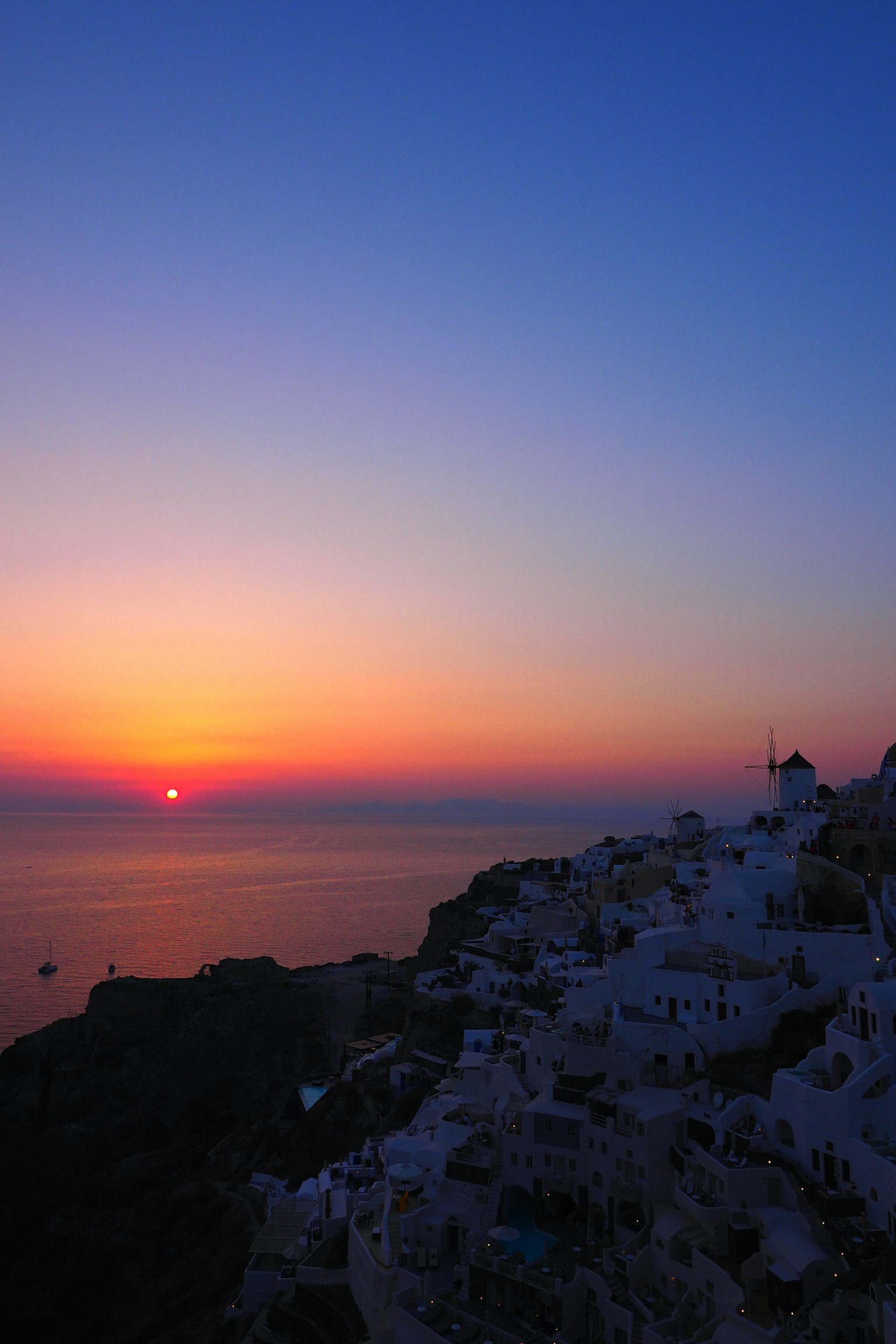Schöner Sonnenuntergang über dem Meer in Santorin weiße Gebäude am Kliff