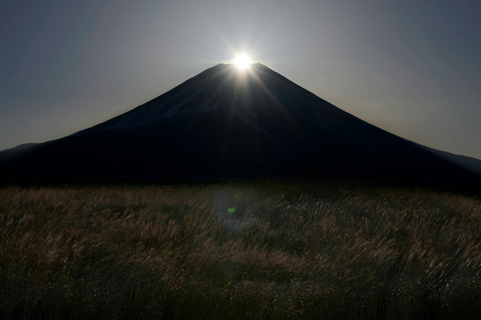 Silhouette del Monte Fuji con il sole che brilla sopra