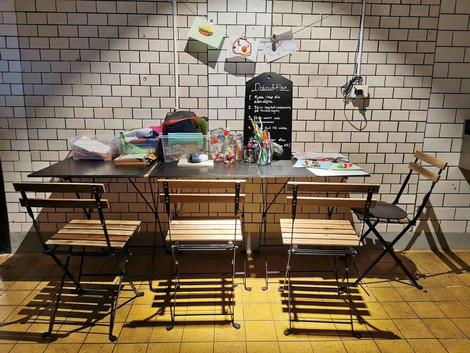 Un rincón de café con sillas de madera y una mesa con artículos de papelería de colores
