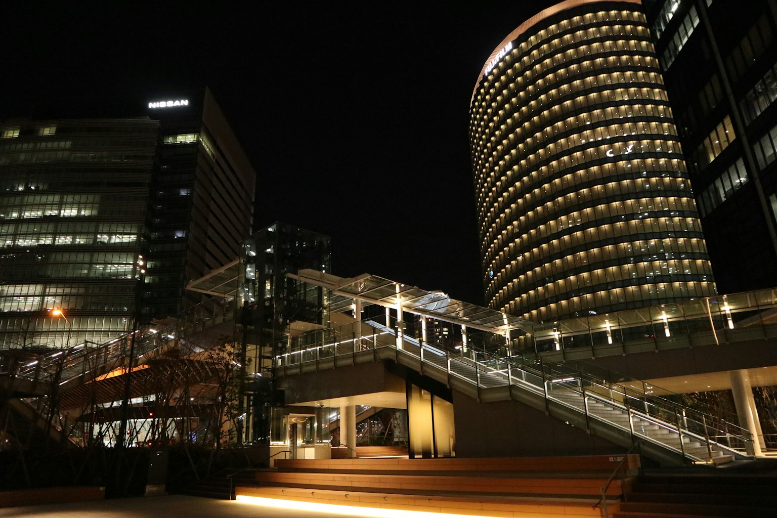 Moderne Stadtlandschaft bei Nacht mit beleuchteten Gebäuden und Treppen