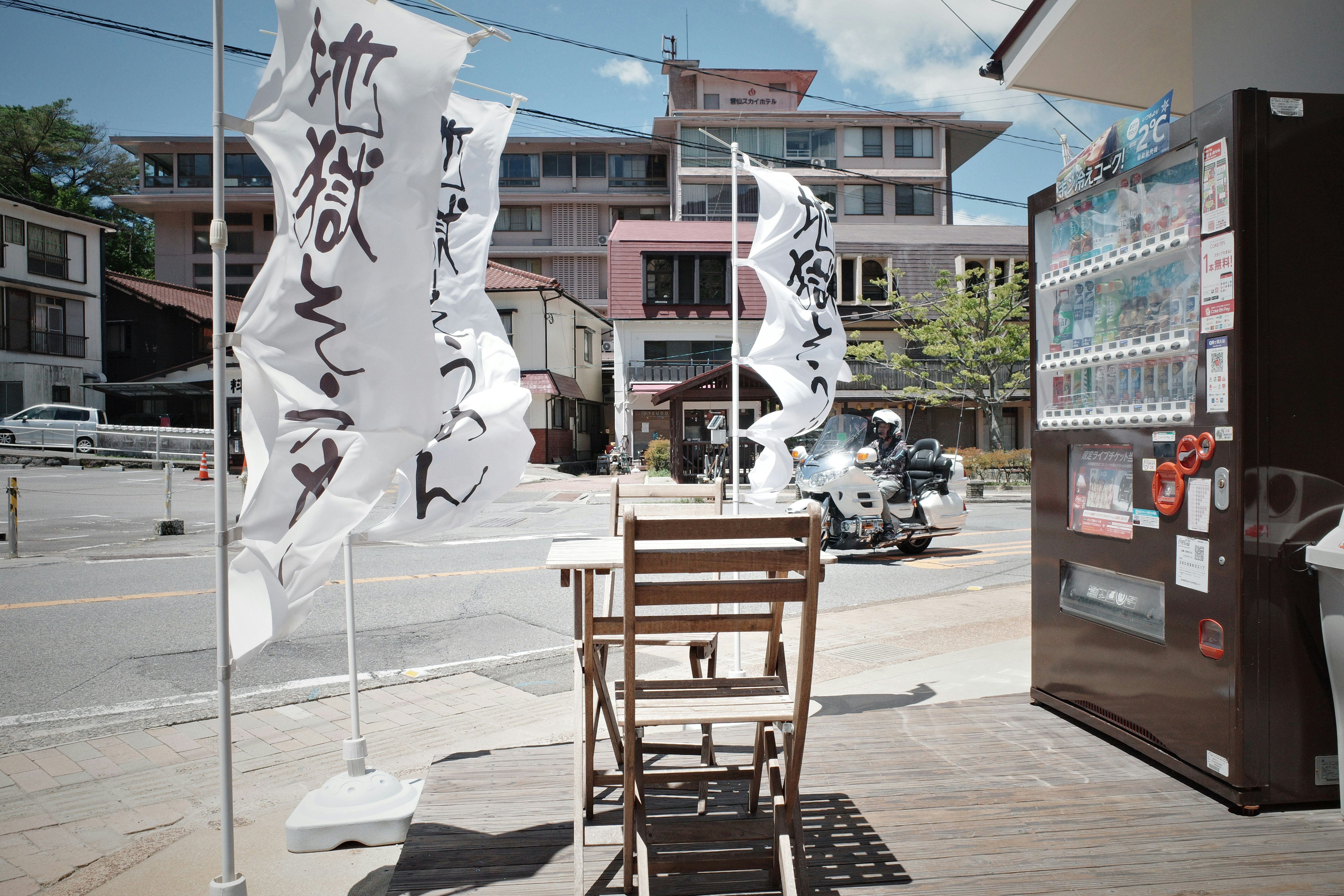 outdoor street-corner event setup with banners, chairs, and display boards
