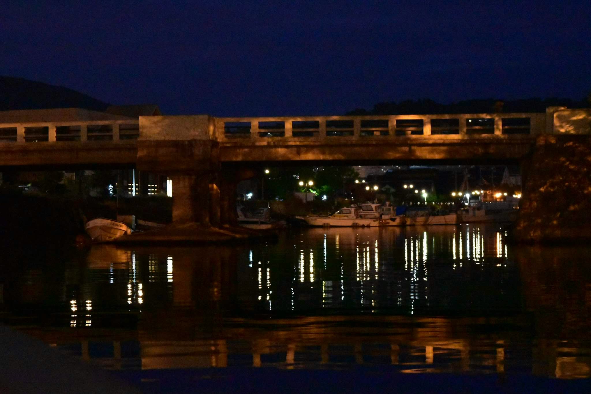 Vista notturna di un ponte illuminato riflesso in un fiume