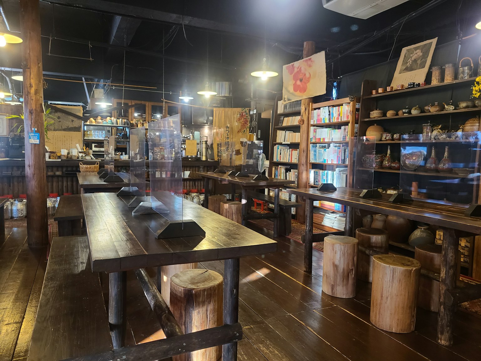 Espacio de exhibición interior con mesas y estanterías de madera creando una atmósfera tranquila