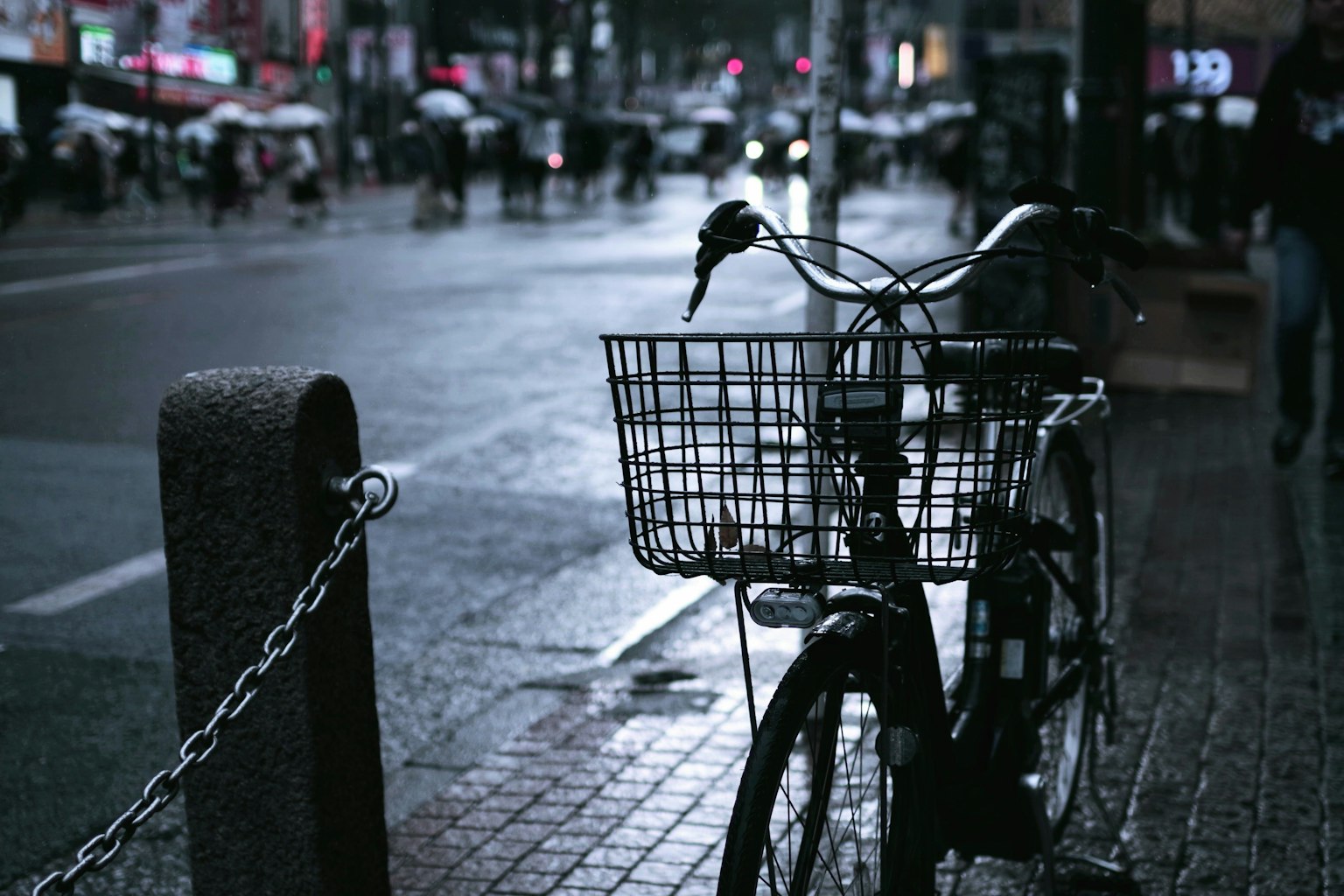 Una bicicletta parcheggiata su una strada bagnata con un'atmosfera scura e riflessi