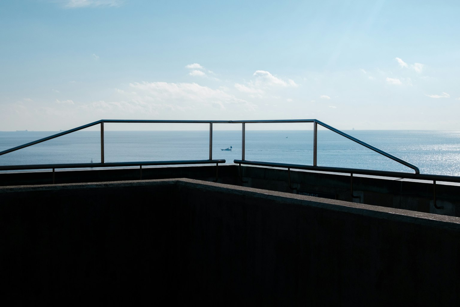 Geländer mit Blick auf das Meer und Betonrand