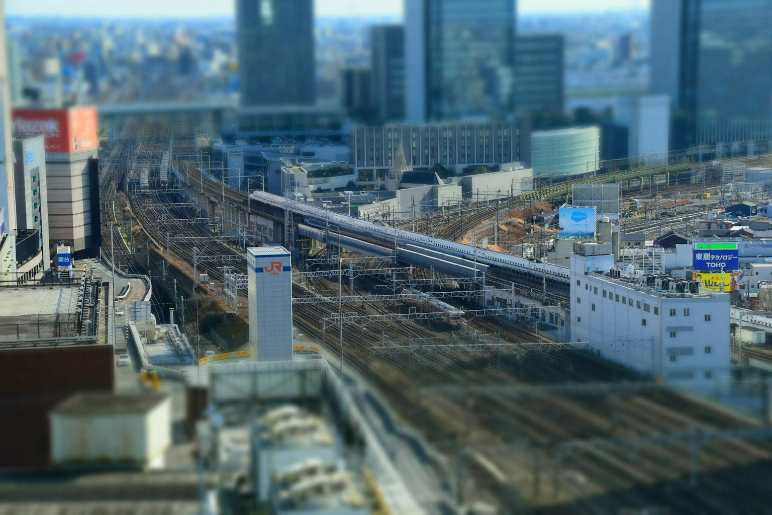 Una escena ferroviaria entre rascacielos que muestra el contraste entre trenes y edificios