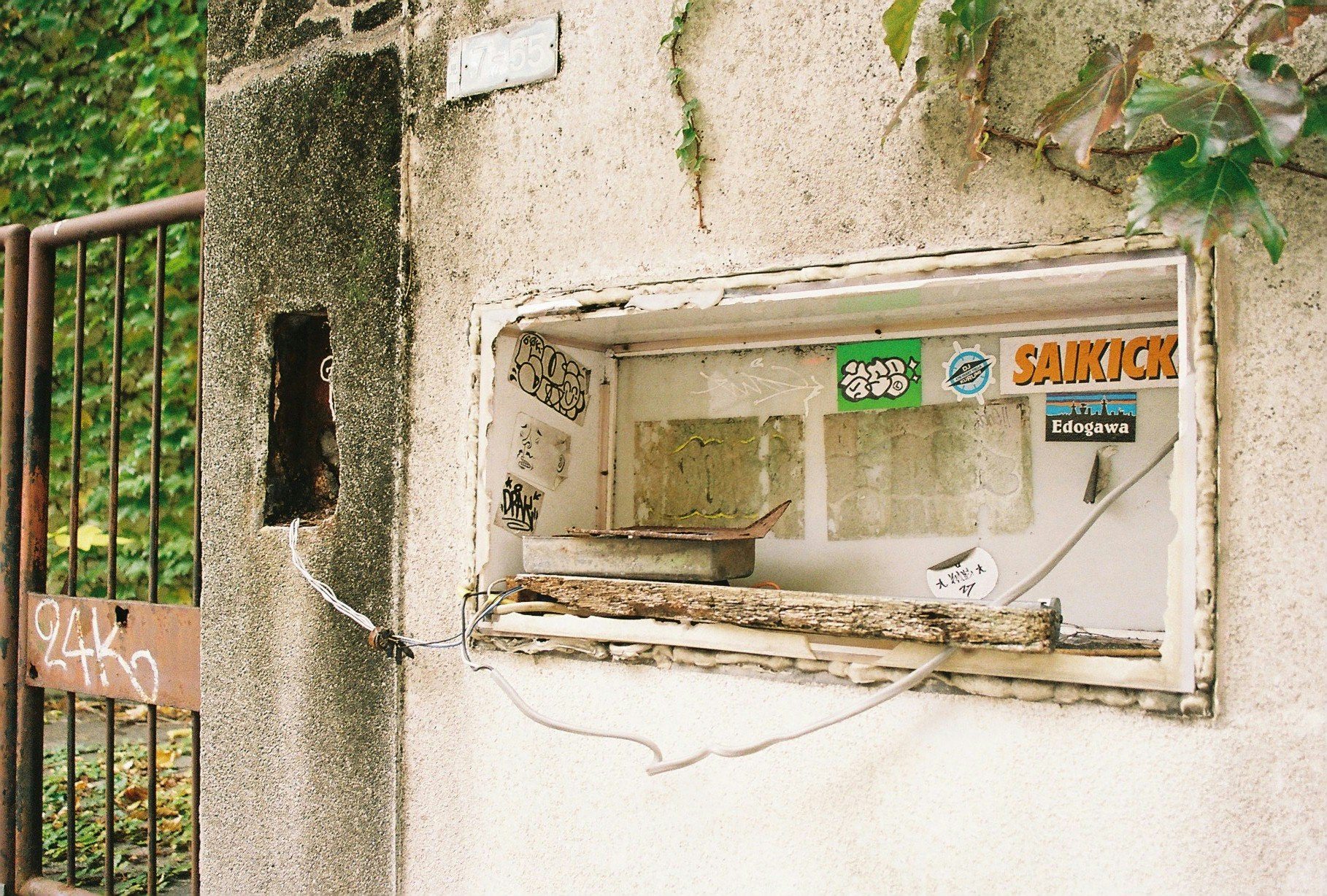 壁に埋め込まれた古い自販機のある路地の一角