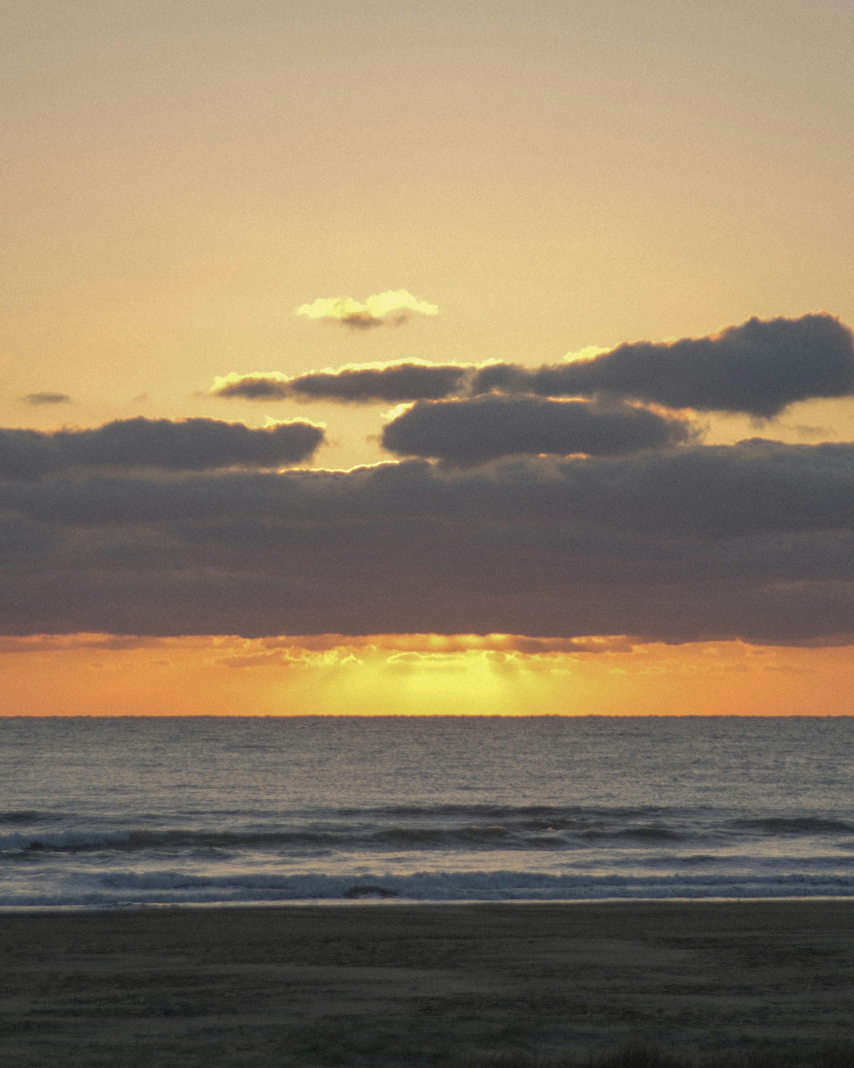 夕暮れの海辺に広がる水平線と雲の夕焼け