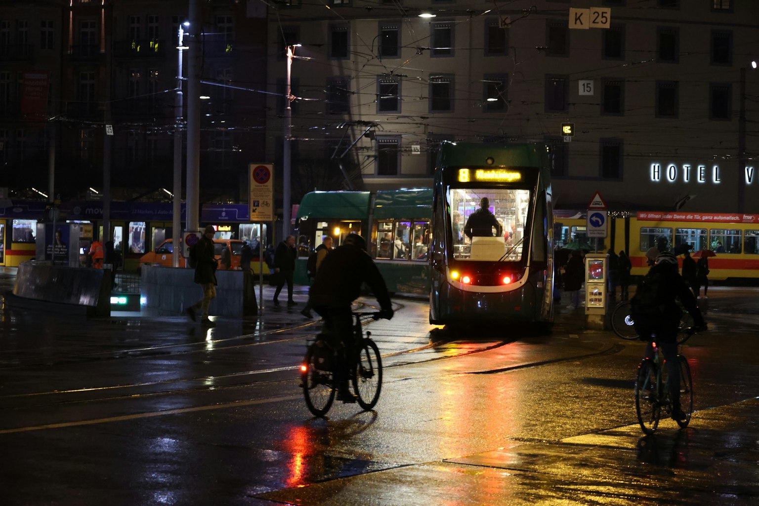 Szene von Radfahrern und Straßenbahnlichtern in einer Stadt bei Nacht
