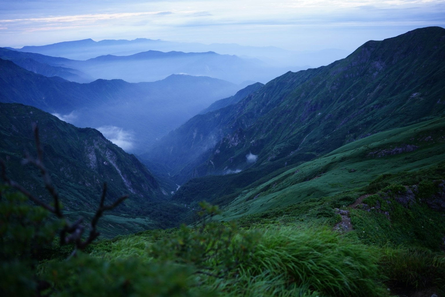 藍色山脈和霧氣瀰漫的山谷的風景