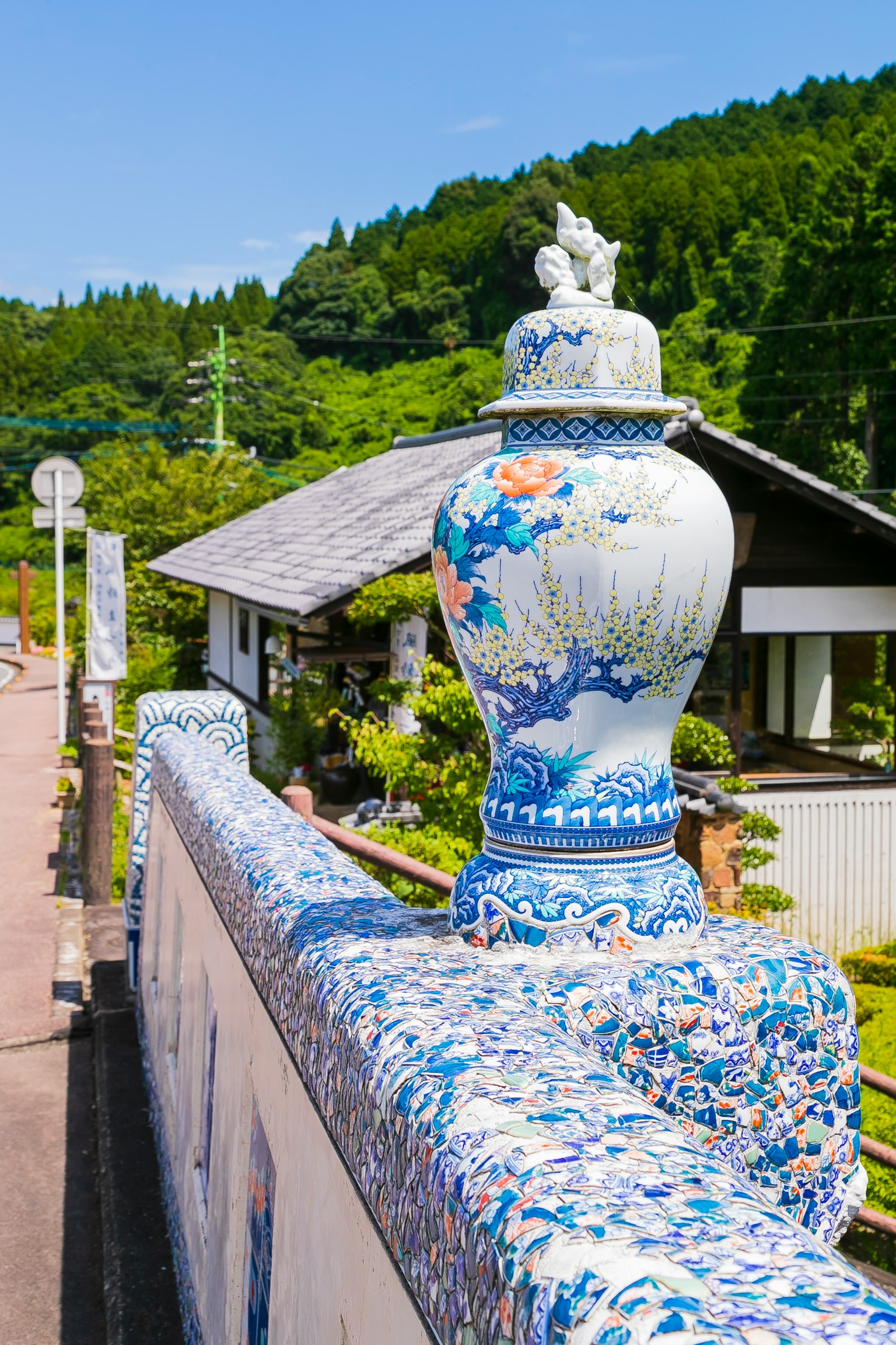 แจกันเซรามิกสีน้ำเงินและสีขาวที่สวยงามวางอยู่บนกำแพงสวน