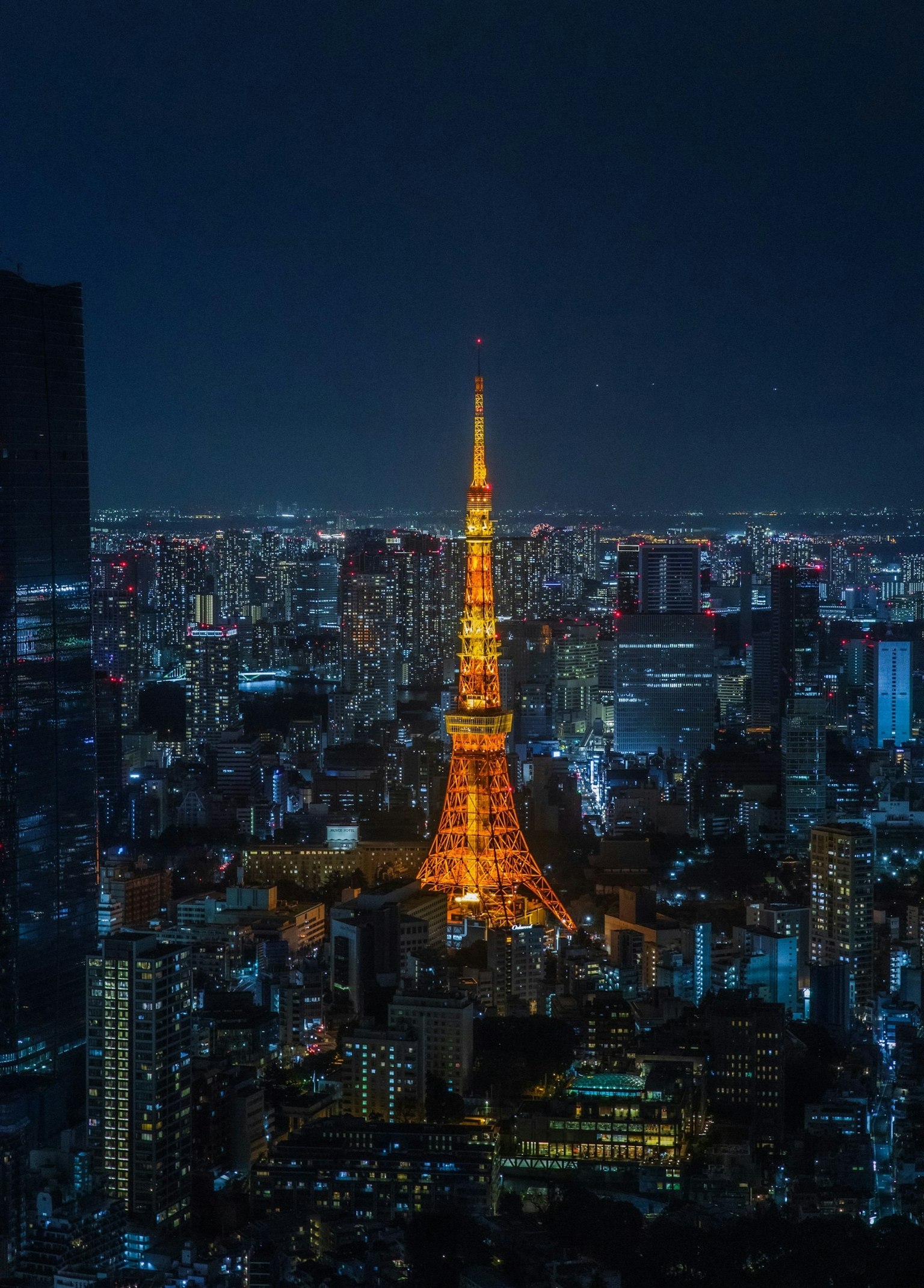 東京塔在夜間照亮充滿活力的城市天際線