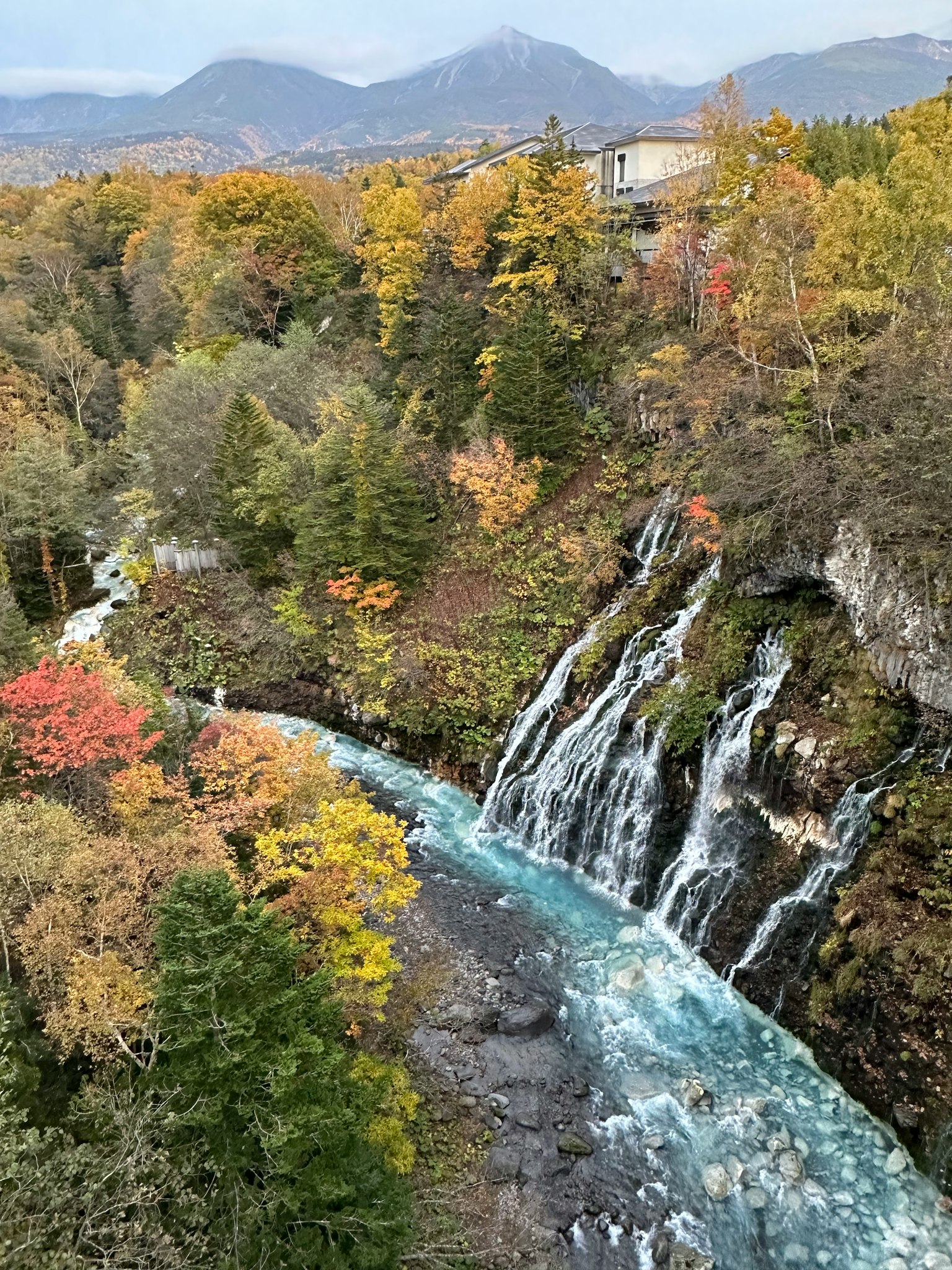 Paesaggio autunnale vibrante con una cascata e un fiume