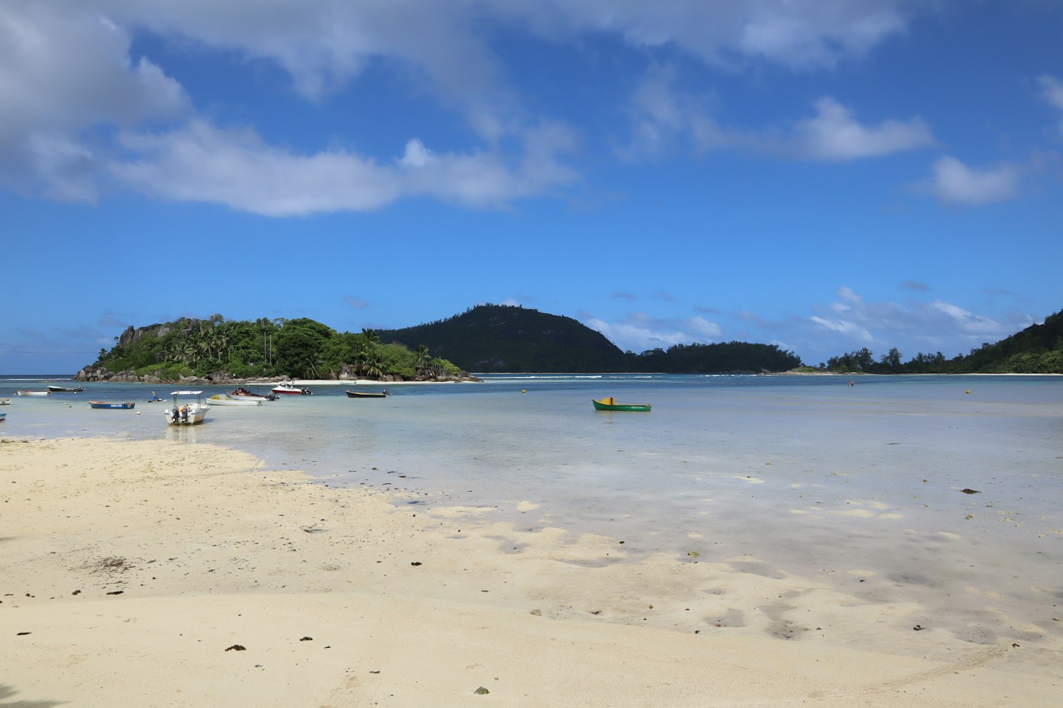 美丽的海滩场景，蓝天和白沙，绿色岛屿和宁静的海水